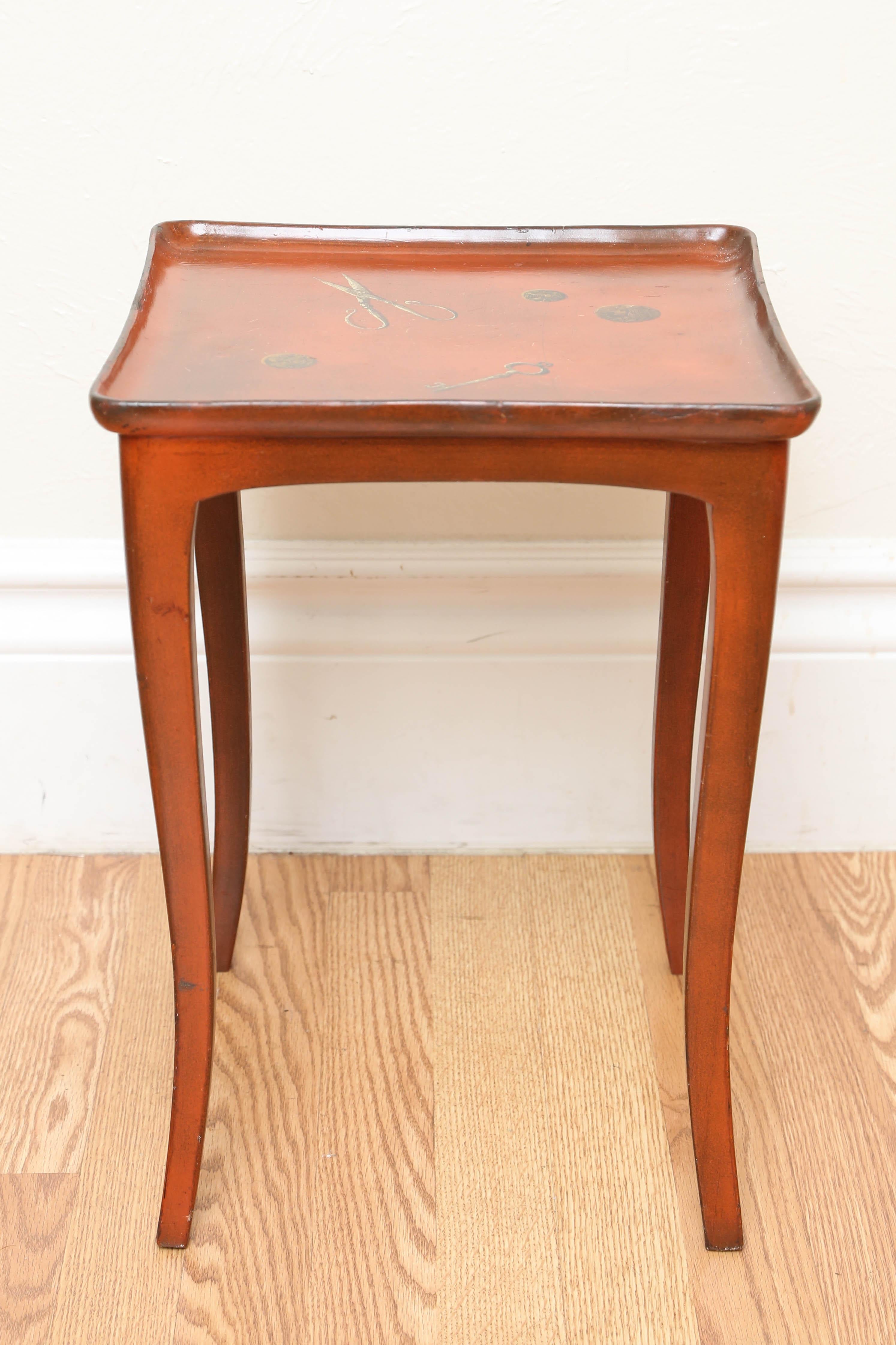 Chinese red lacquered side table with Trompe L' Oeil top featuring a scissor, key & coins.