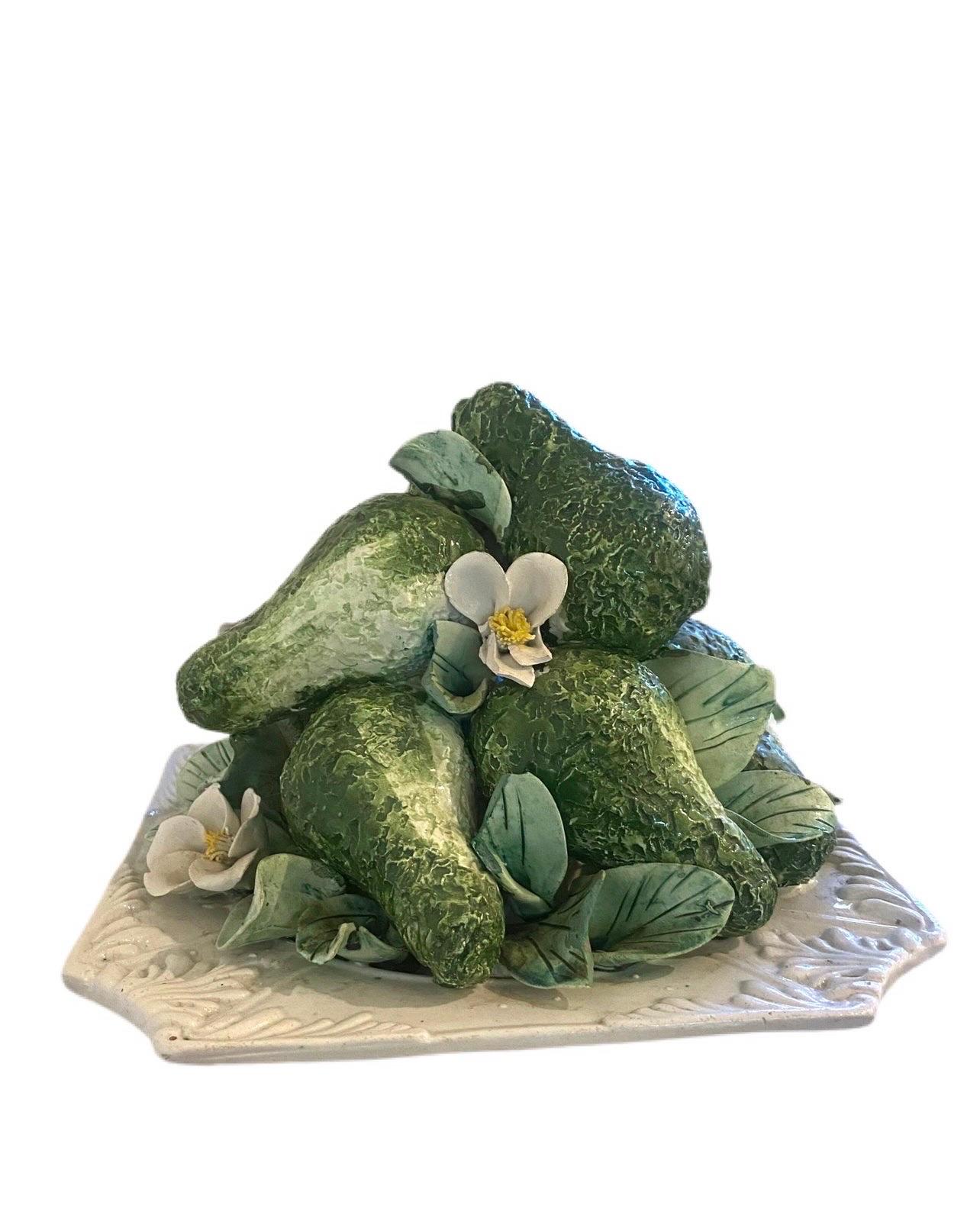 Wonderfully handcrafted greens with delicate white flowers where avocados sit piled on top of one another.