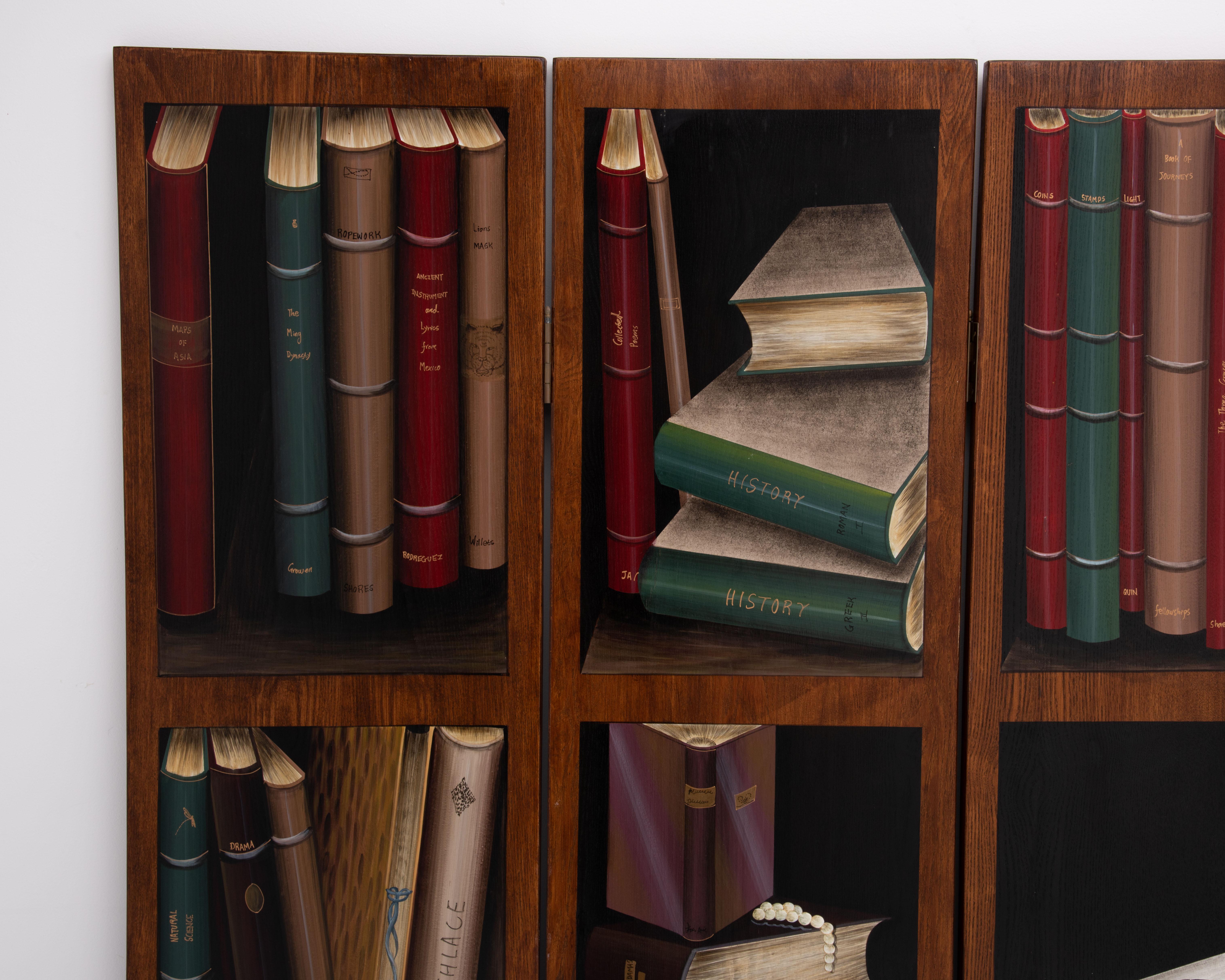 Un separador de ambientes de estilo trampantojo que representa viñetas de libros y bibliotecas vintage pintadas en una sola cara de paneles de madera de una pulgada de profundidad. La parte trasera no está decorada. Mide 72