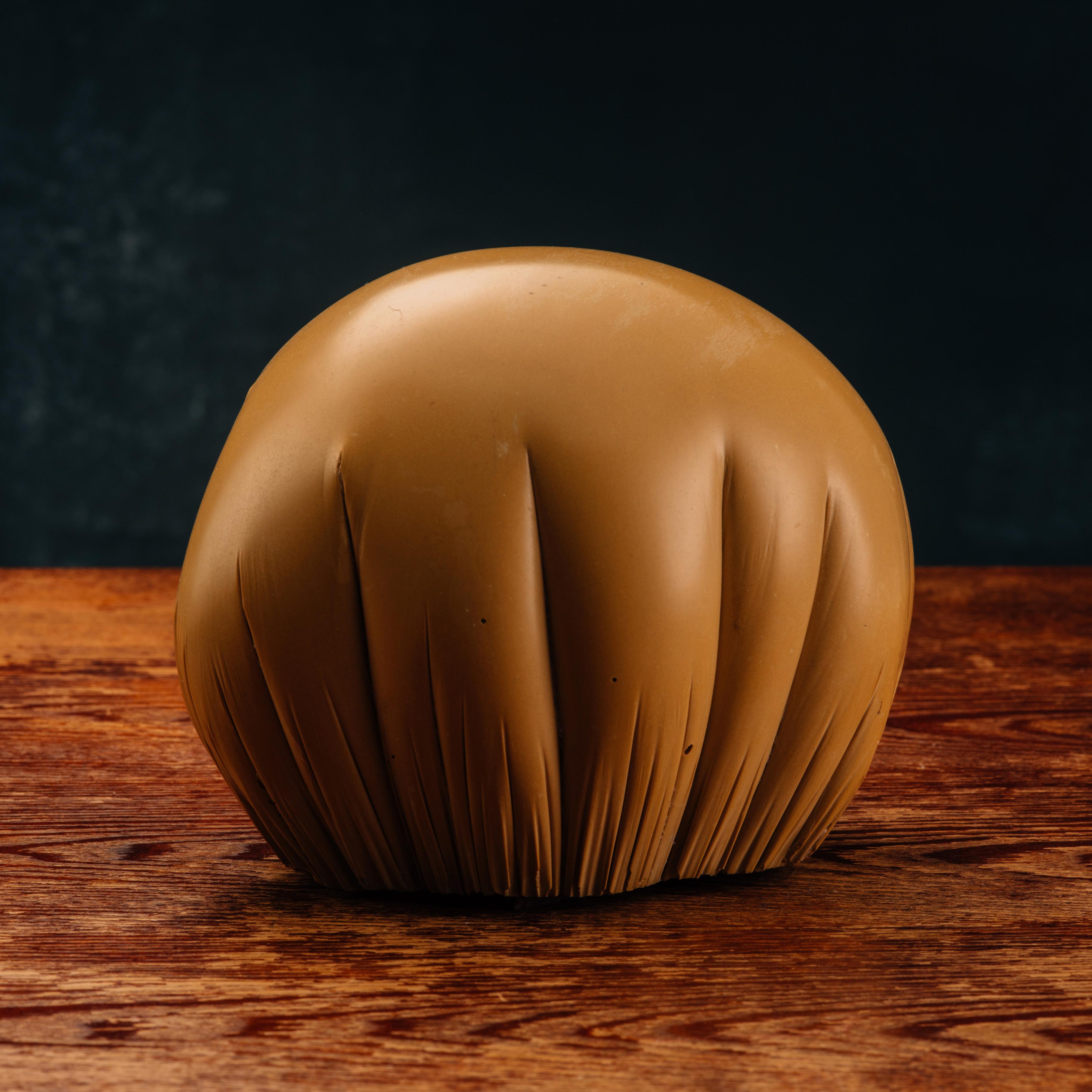 A highly effective trompe l’oeil tabletop sculpture formed in tinted and polished solid cast stone to resemble a leather pouf. Well-executed by an anonymous artist. European in origin, likely late 20th century.