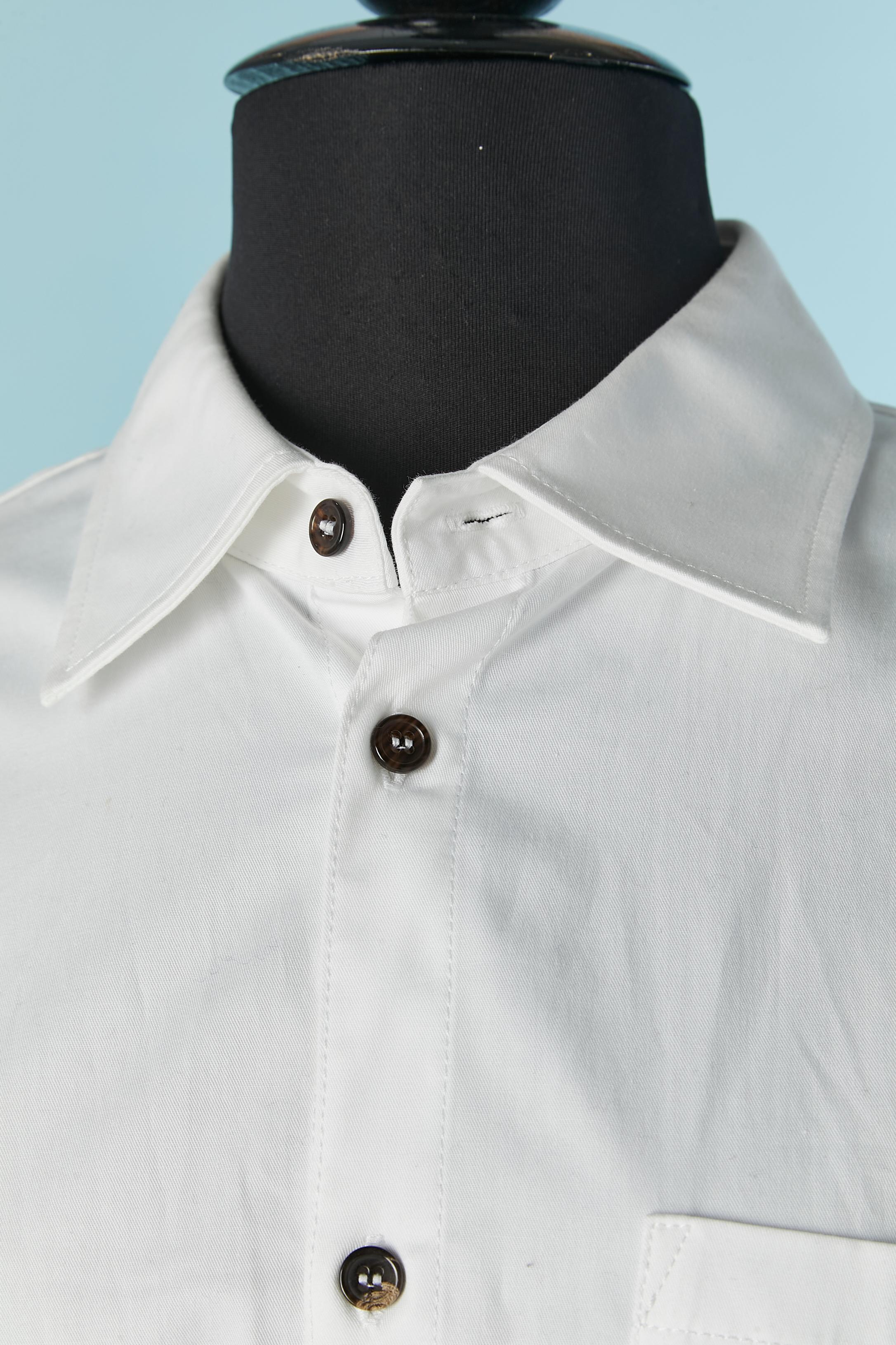 White cotton dress in Trompe l'oeil like a shirt and skirt. Button and buttonhole closure on the middle front and same on the skirt with zip. Button and buttonhole on the cuffs as well. Pocket on both side on the skirt + two pockets on the back. One