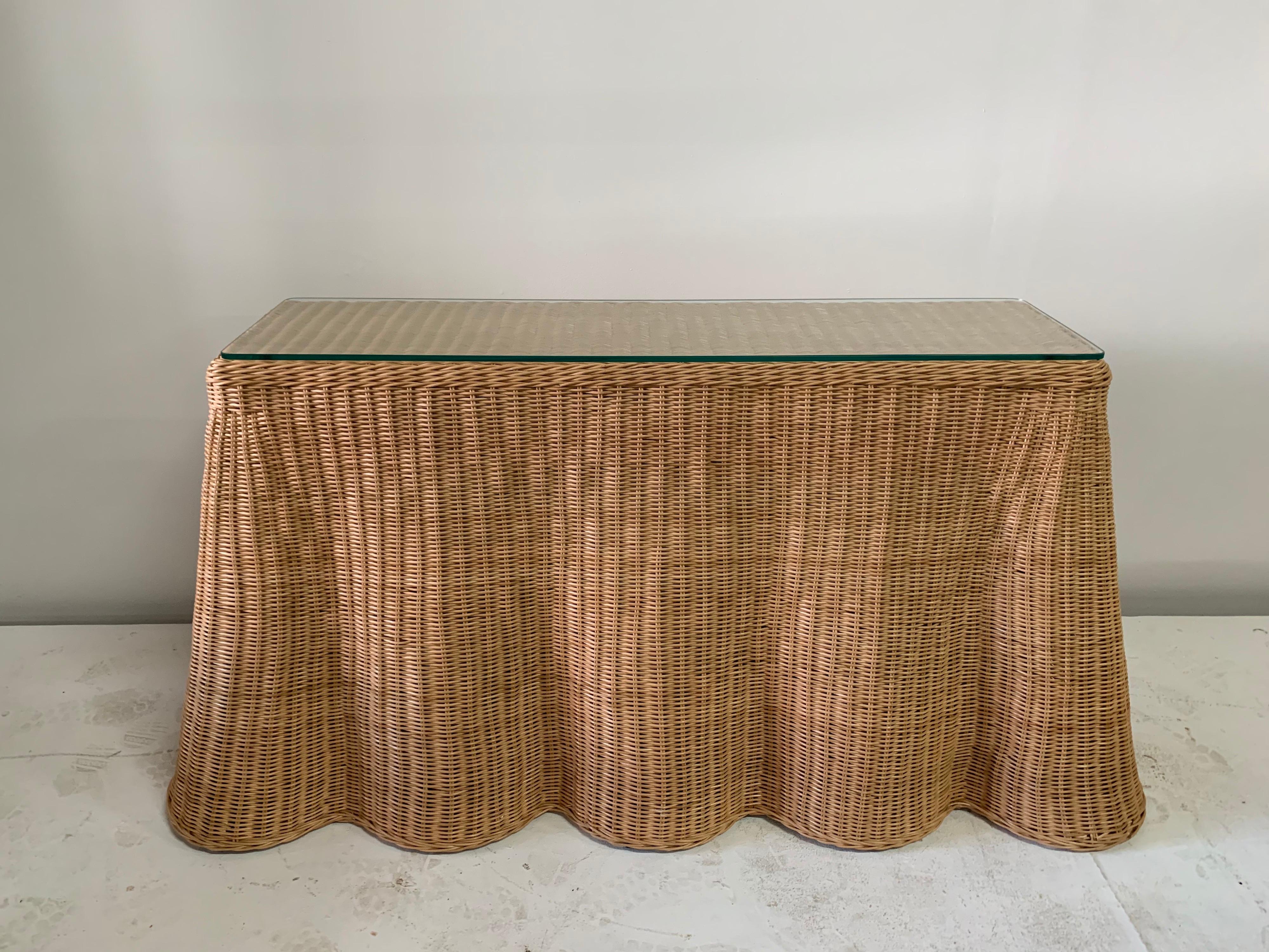 Finely crafted, this vintage draped wicker console table is one of the largest we have seen and sold. Bottom/base has been covered in black fabric, as originally found and glass protector top as well.

Note: Dimensions of the wicker table listed