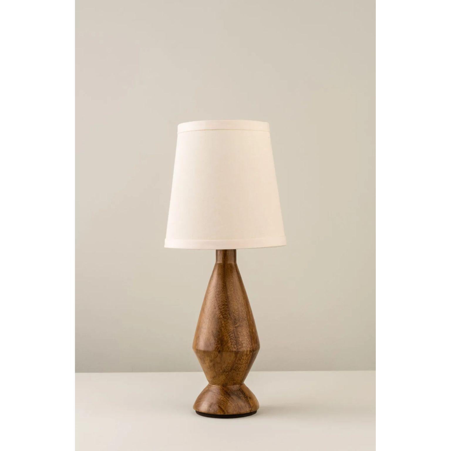 Trompo Table Lamp by Isabel Moncada
Dimensions: Ø 15.5 x H 35.5 cm.
Materials: Parota wood base and styrene screen lined with fabric.

Trompo is a traditional Mexican wooden toy that rotates on its axis, similar to this small and graceful rhomboid