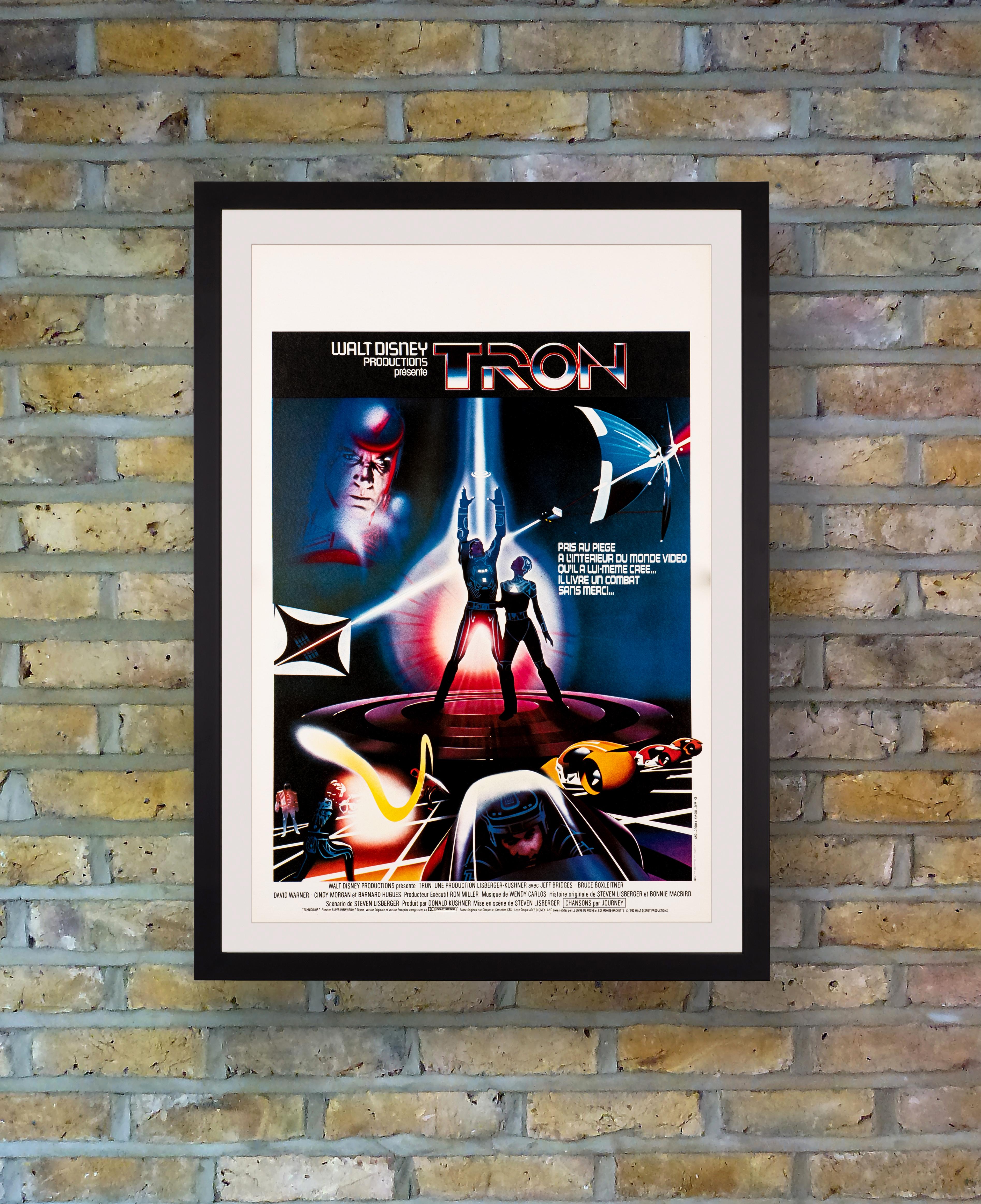 A vibrant French Petite poster for Walt Disney's pioneering 1982 sci-fi adventure 'Tron.' Written and directed by Steven Lisberger, the futuristic film starred Jeff Bridges as a computer programmer who is transported into the virtual world of a