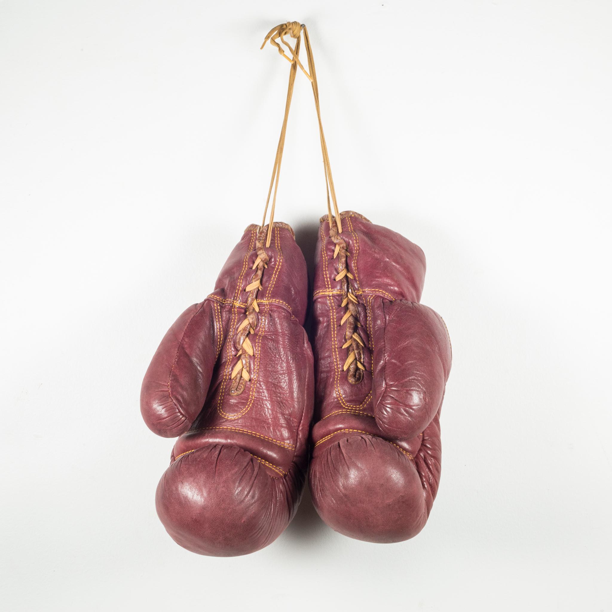 About

This is a original pair of vintage leather boxing gloves filled with horse hair. The gloves are a soft, maroon leather with gold stitching and laces. The are both stamped 