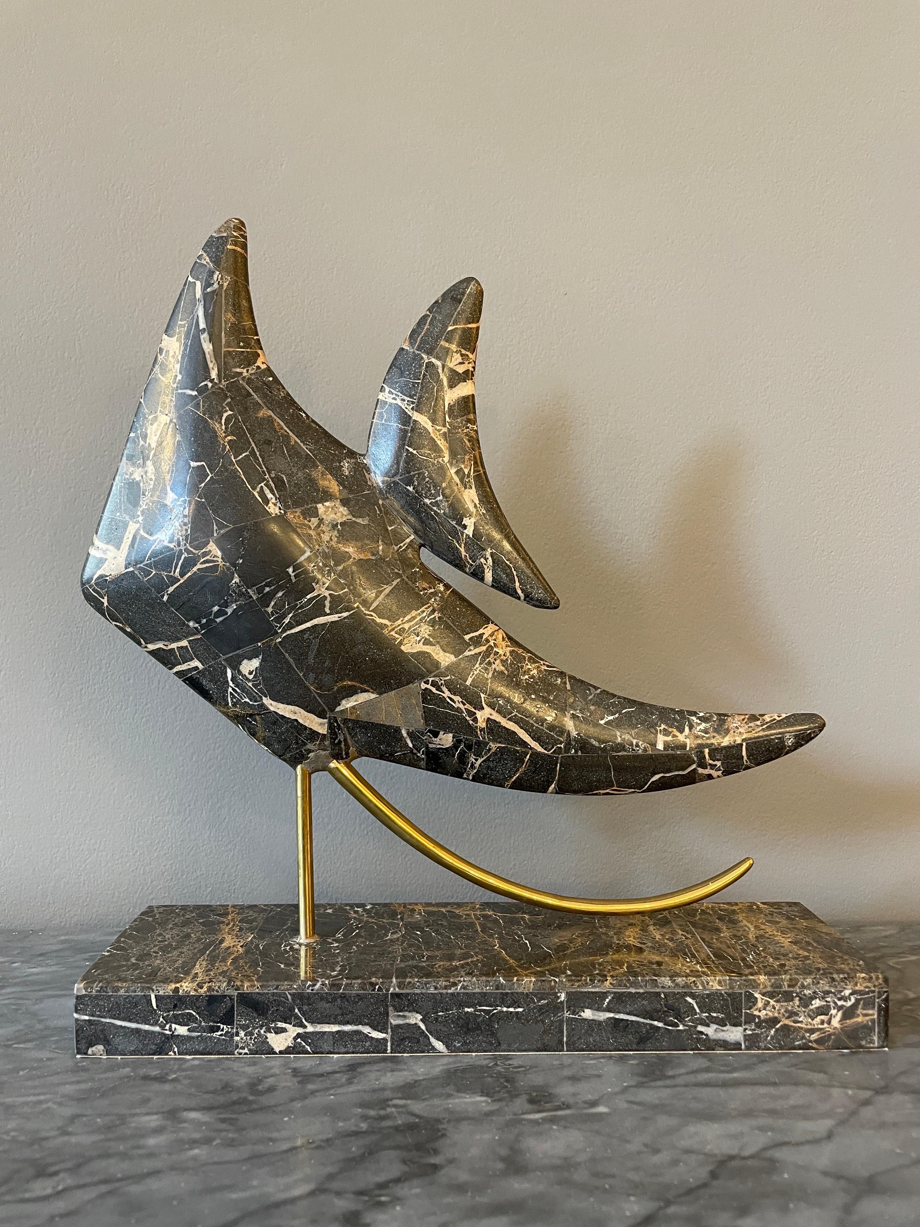 A tropical fish sculpture in Italian Emperador marble and brass. The fish covered in marble using the tessellation technique. A tessellation or tiling is the covering of a surface, using one or more geometric shapes, called tiles, with no overlaps