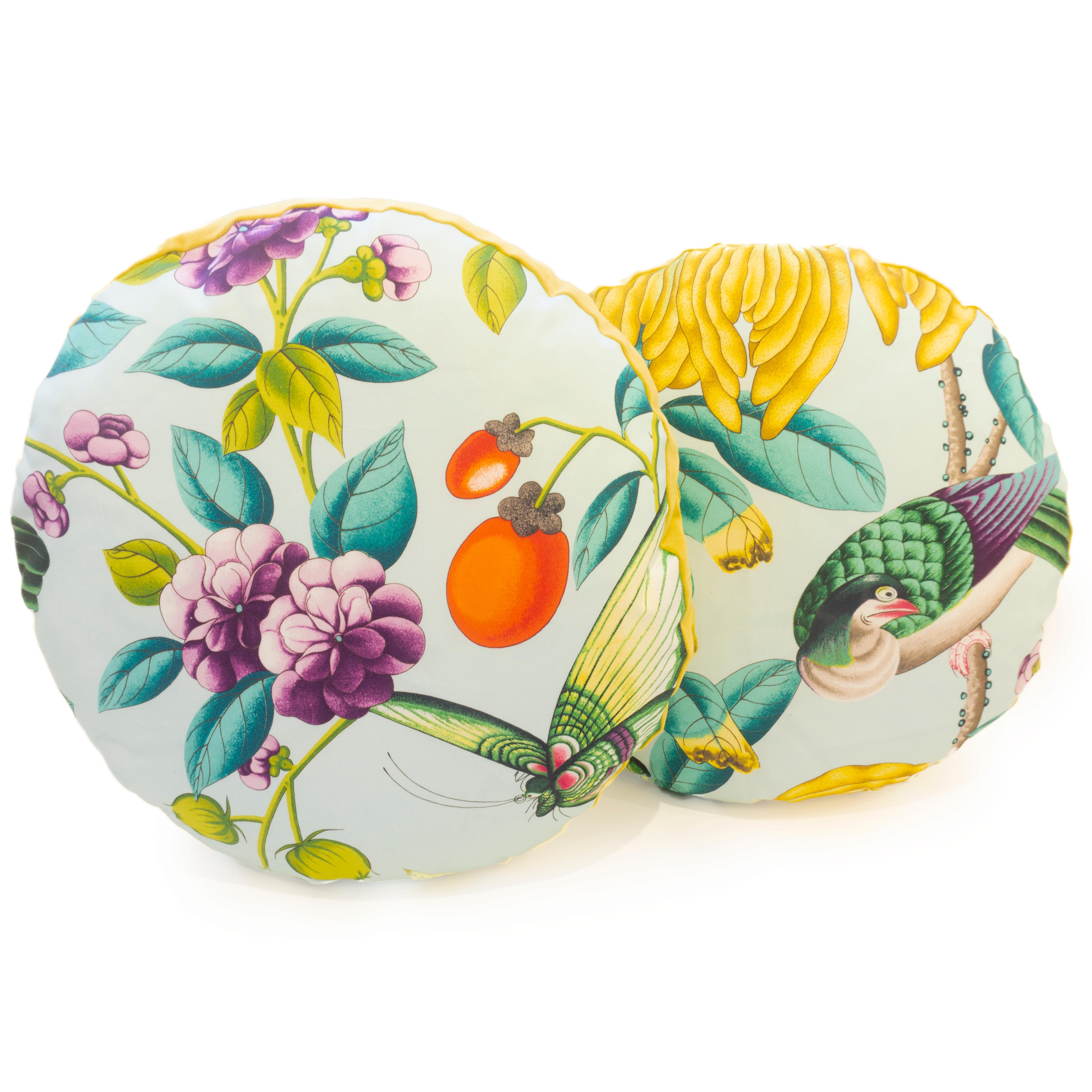 Handcrafted round throw pillows sewn in a fabric featuring flowers, leaves and birds in vibrant colors. The back is sewn in a golden yellow velvet. Made in our studio in Norwalk, Connecticut. This pillow can also be made to order with your own