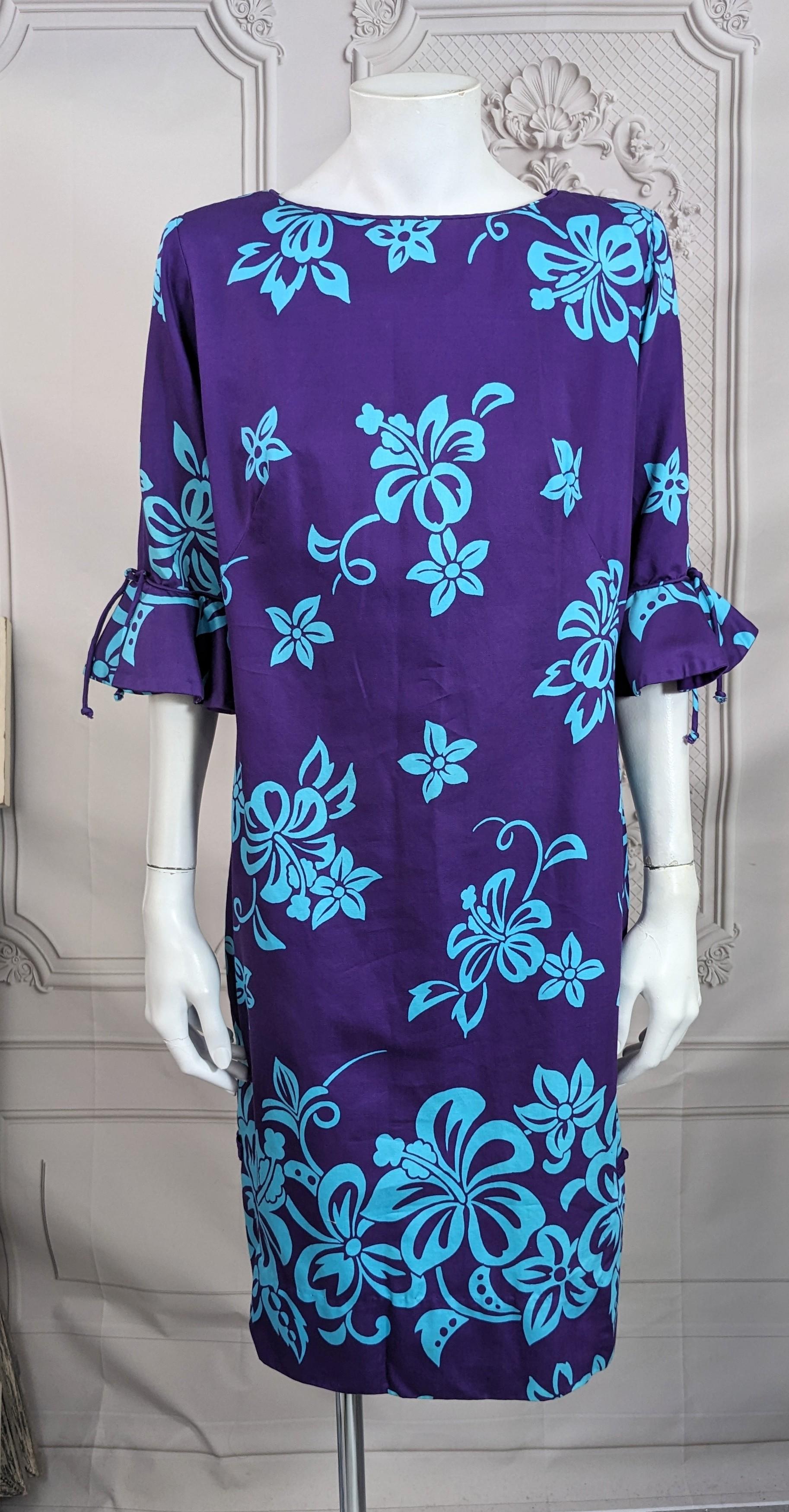 Charming Tropical Print Mid Century Sheath in polished cotton from the 1960's. Aqua florals on deep purple ground. Simple straight cut with 3/4 sleeves with flounces with Chinese knot detail at side slits. Back zip entry, retailed at Lord and