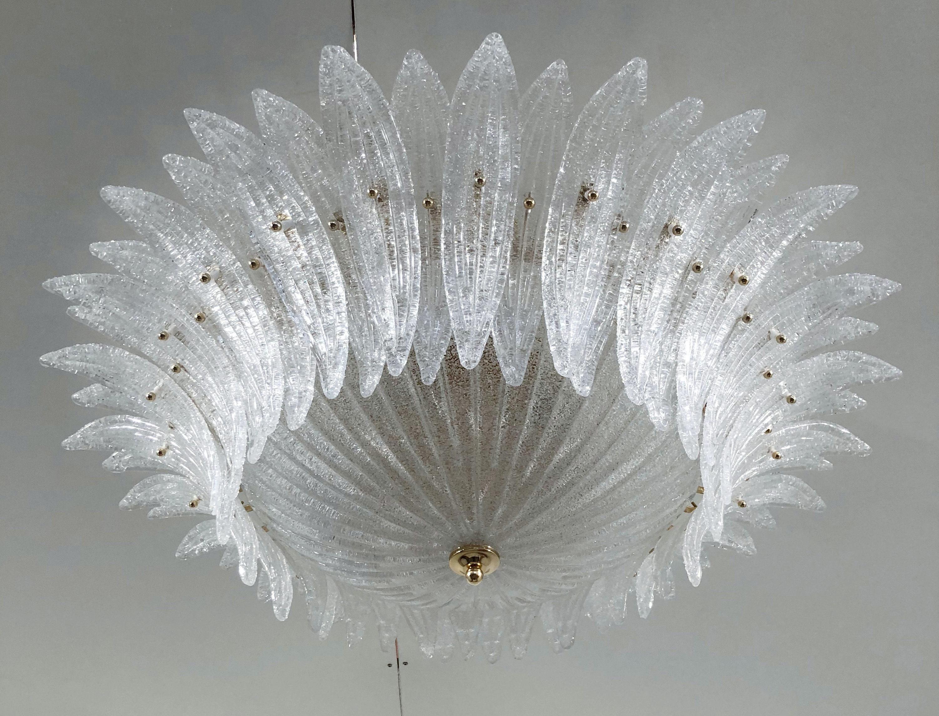 Lustre encastré Palmette en verre clair de Murano avec des feuilles de texture granuleuse selon la technique Graniglia, monté sur une monture en métal plaqué or 24k / Fabriqué en Italie
6 lampes / type E26 ou E27 / max 60W chacune
Diamètre : 36