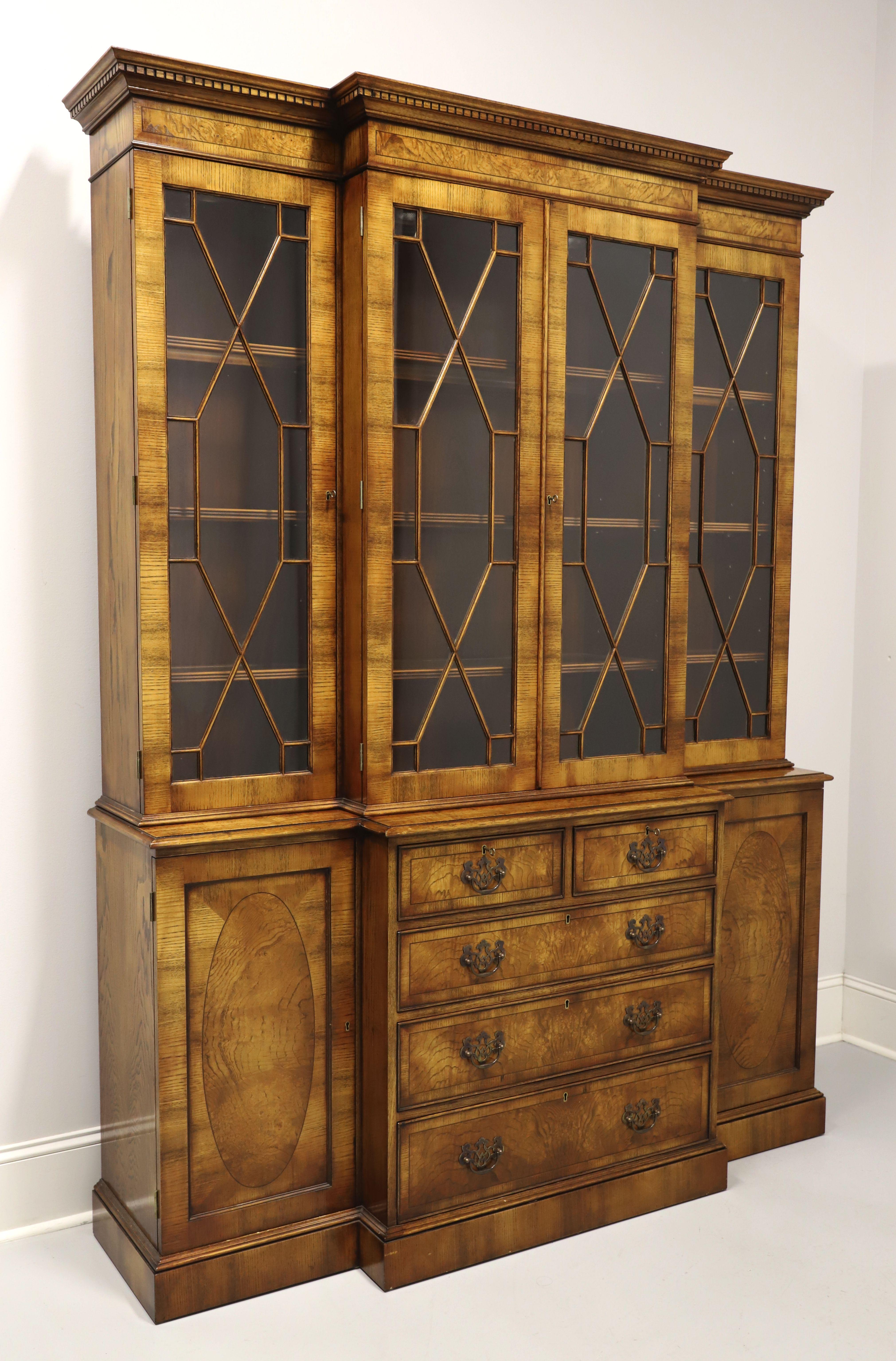A Chippendale style breakfront china cabinet by Trosby Furniture. Burlwood & oak with a slightly distressed finish, brass hardware, crown & dentil moulding to top, paned fretwork glass doors, banded door & drawer fronts, bevel edge to top of lower