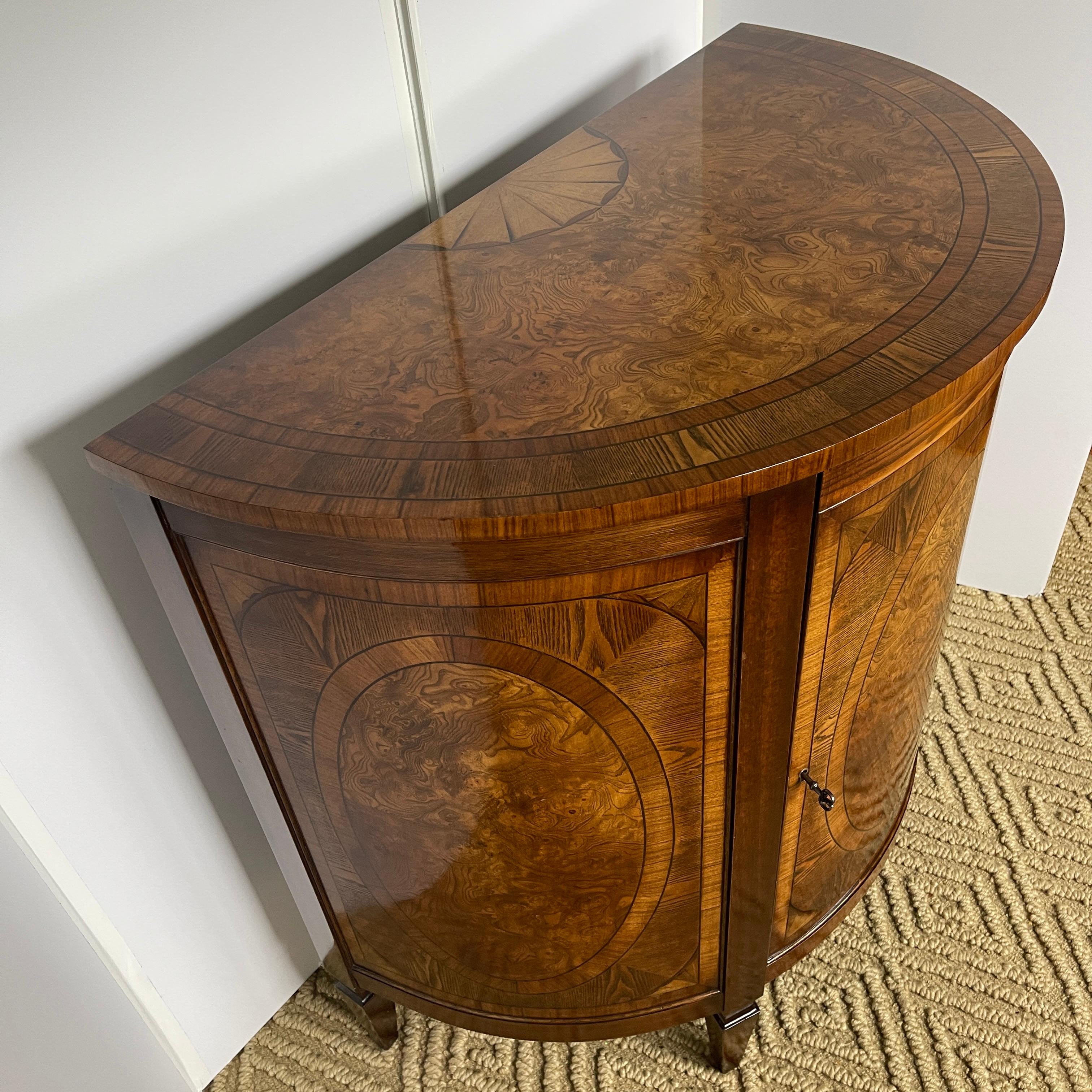 Demi-lune mahogany and yew wood demi-lune dresser cabinet.
Made in England, this beautiful wood dresser or cabinet is as comfortable in a bedroom as it is in a foyer or living room. The wood glows; it's classical shape will lend itself to any decor
