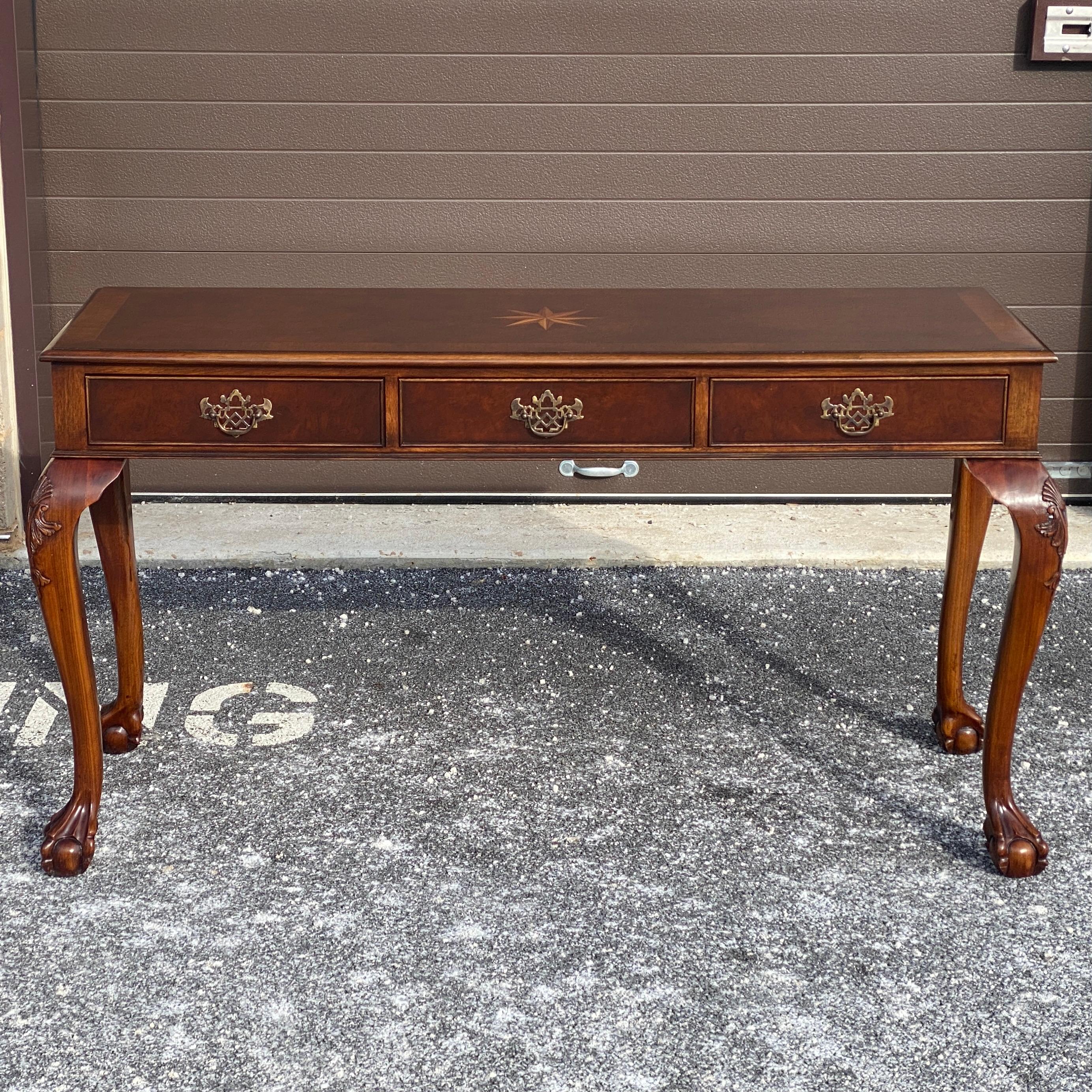 Konsolentisch von Trosby Furniture mit drei Schubladen und Beschlägen aus massivem Messing in Antik-Optik. Handgeschnitzte Cabriole Beine mit Kugel und Klaue Füße. Handgefertigt von Meisterhand in Sussex, England.
Oberteil ist 56