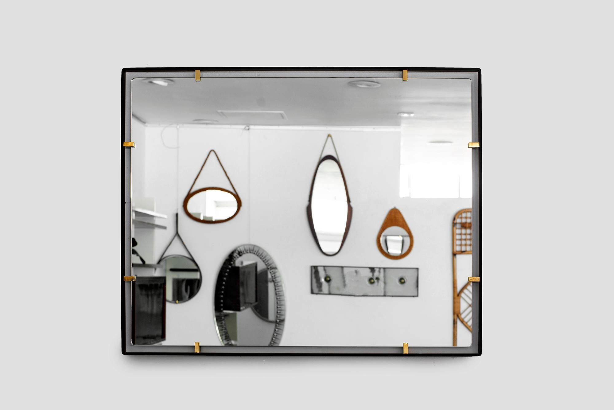 Iron frame and polished brass clasps support a floating rectangular mirror. Modeled after a vintage Italian design, newly produced at orange. Customizable sizes and finishes available.