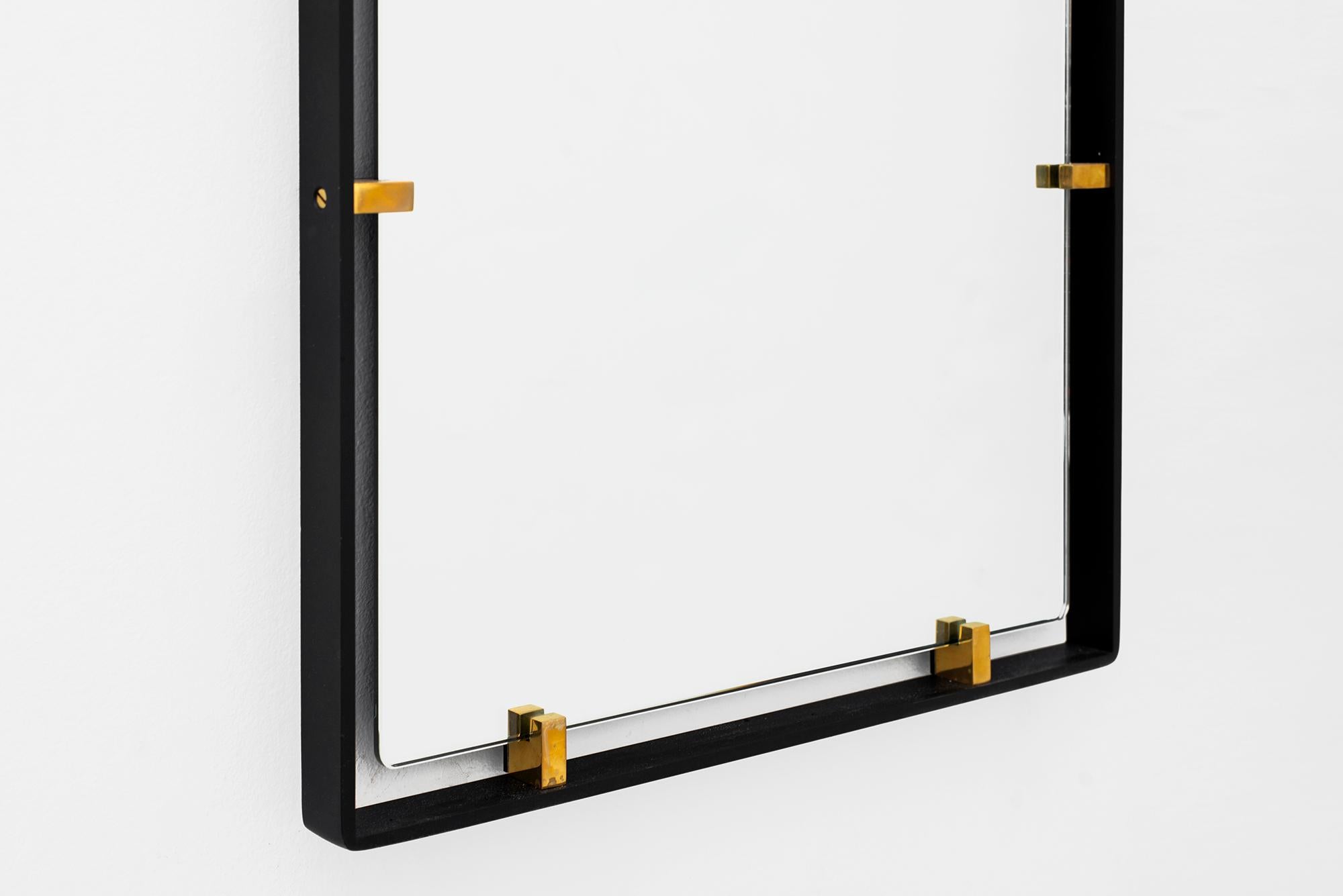 Iron frame and polished brass clasps support a floating rectangular mirror. 
Modeled after a vintage Italian design, newly produced at orange. 
Customizable sizes and finishes available.