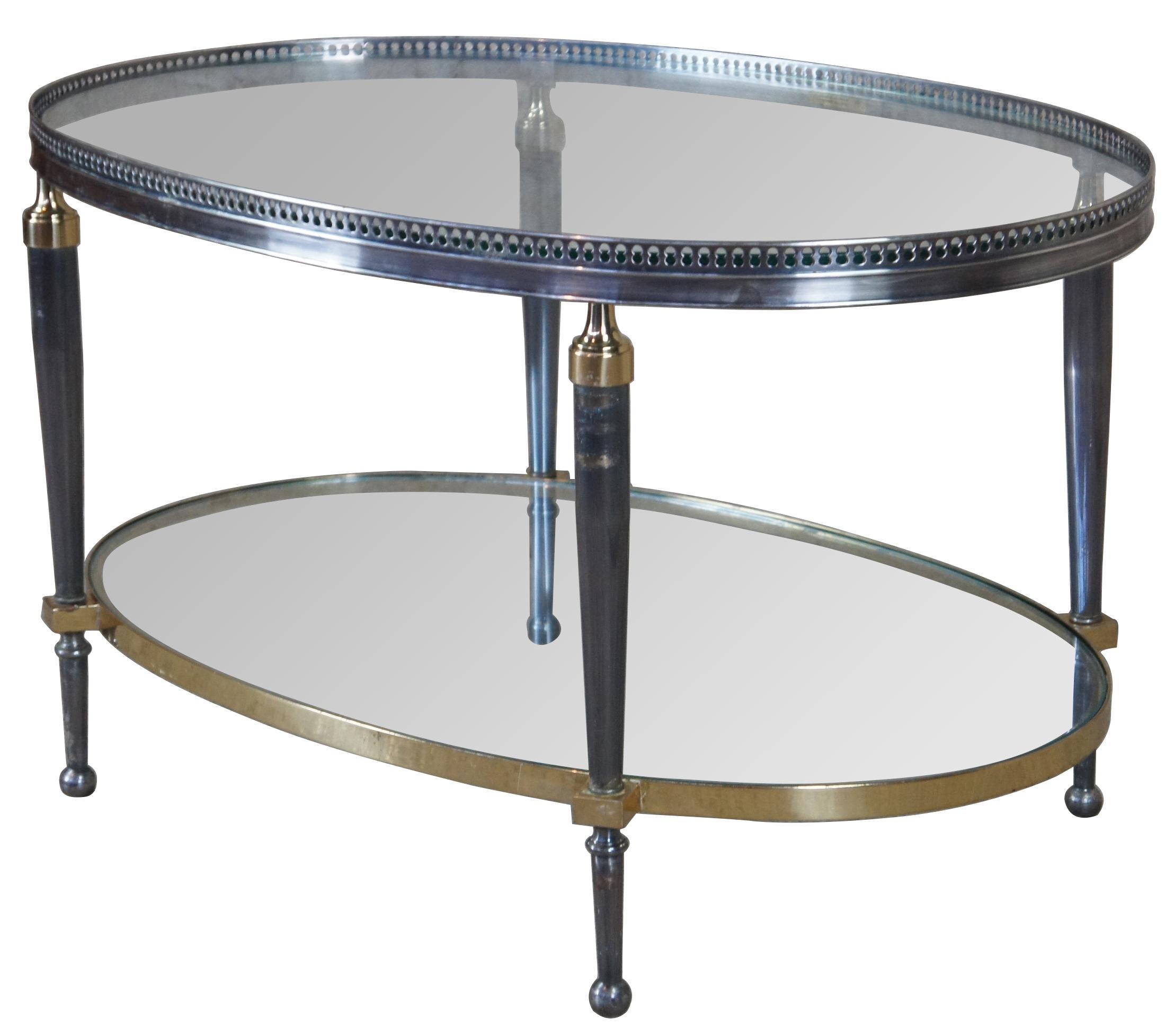 Late 20th century oval form coffee table by Trouvailles Inc of Watertown, Ma. Made from steel and brass with glass inserts. Features a pierced gallery and tapered legs leading to ball feet. Measure: 32