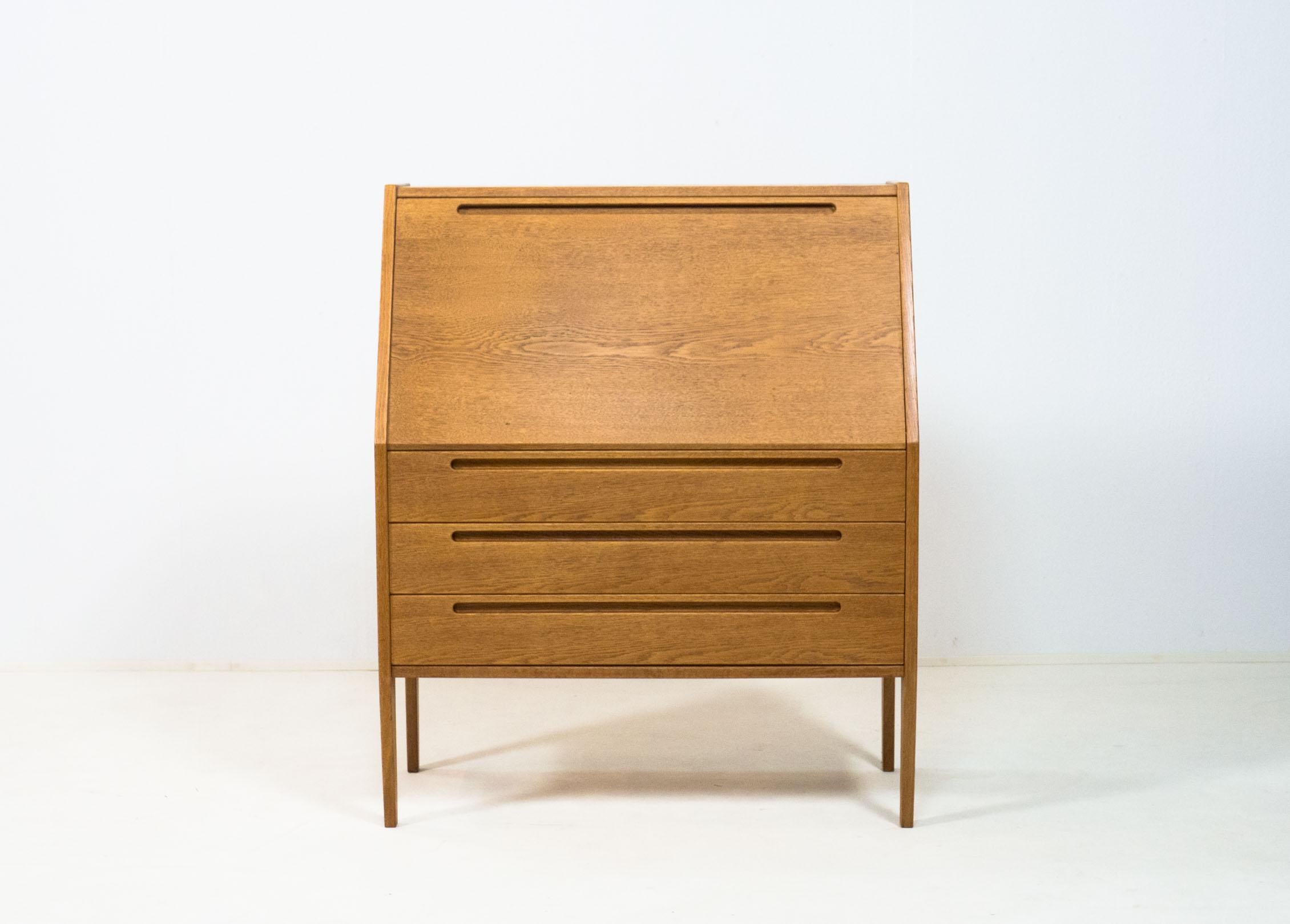 Vintage fold out secretary writing cabinet designed by Kai Kristiansen for Tørring Møbelfabrik of Denmark, 1960s.

This cabinet is veneered in oak and has solid oak embedded feet and edges.
It has three large drawers on the outside and three smaller