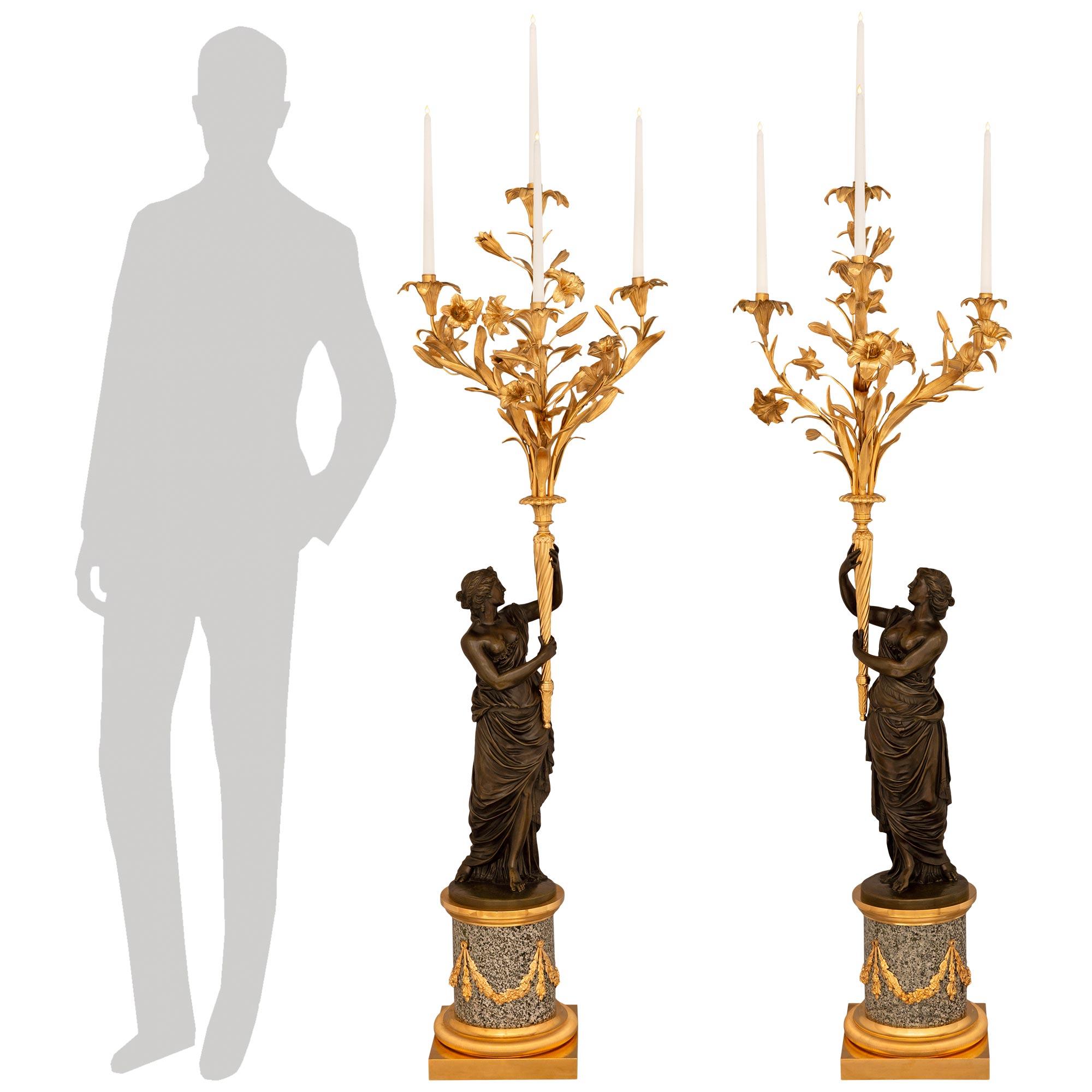 Una monumentale e impressionante coppia di candelabri in granito giallo continentale del XIX secolo, bronzo patinato e Ormolu. Ogni candelabro a quattro bracci, di dimensioni monumentali, è sollevato da una colonna circolare con uno zoccolo in