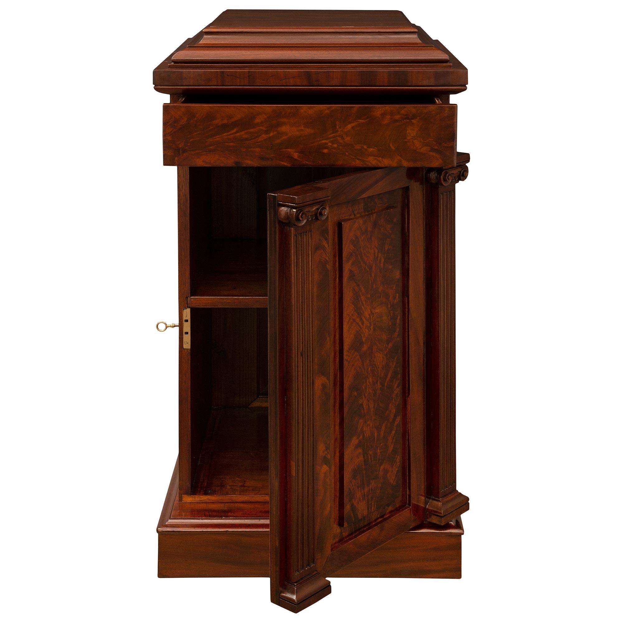 An impressive and extremely decorative large scale true pair of English 19th century Regency period flamed Mahogany pedestal columns. Each one door one drawer pedestal is raised by a straight square base with a fine wrap around mottled border. At
