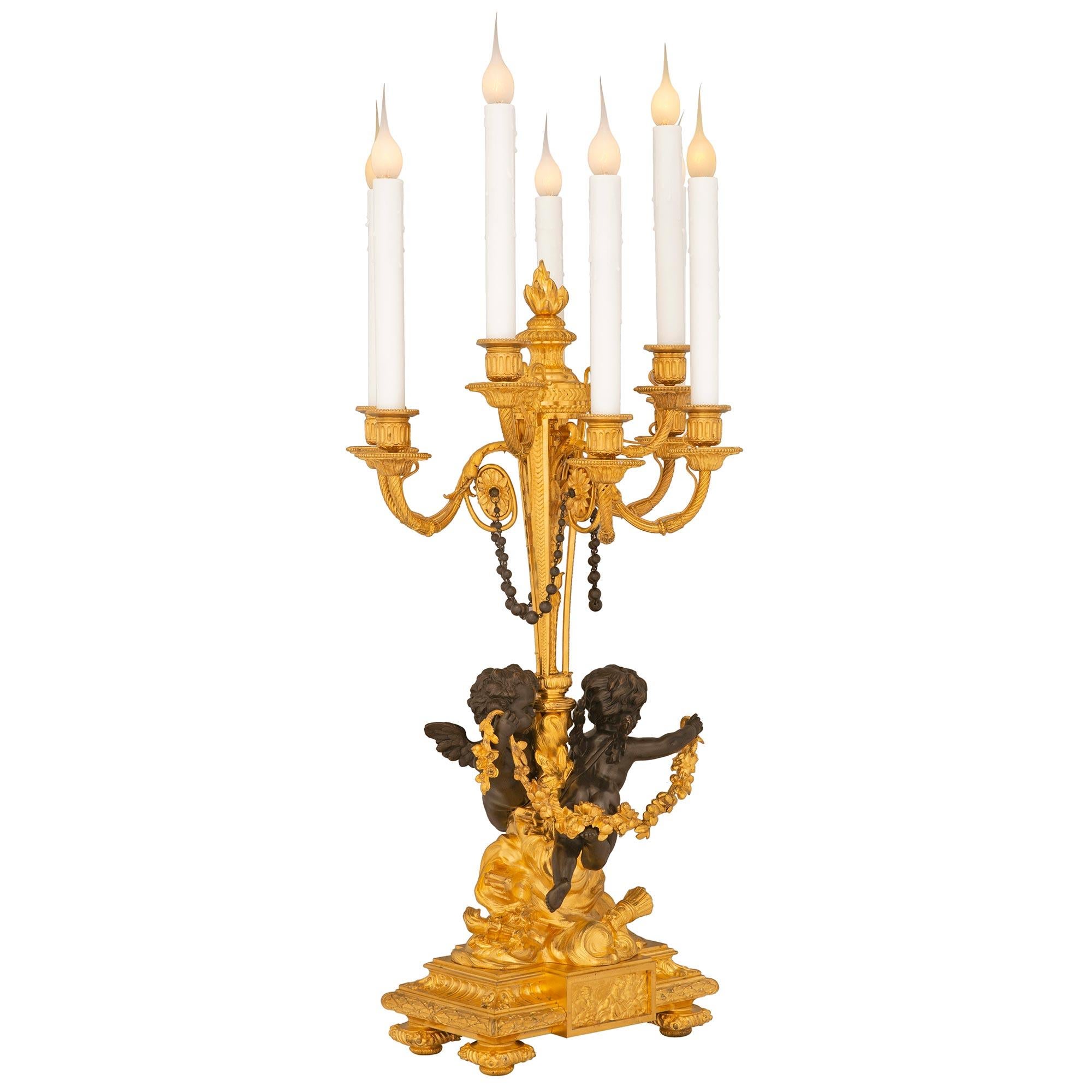 A stunning and extremely high quality true pair of French 19th century Louis XVI st. Belle Époque period patinated bronze and ormolu candelabra lamps possibly by Henri Picard. Each eight arm lamp is raised by fine mottled foliate feet below a