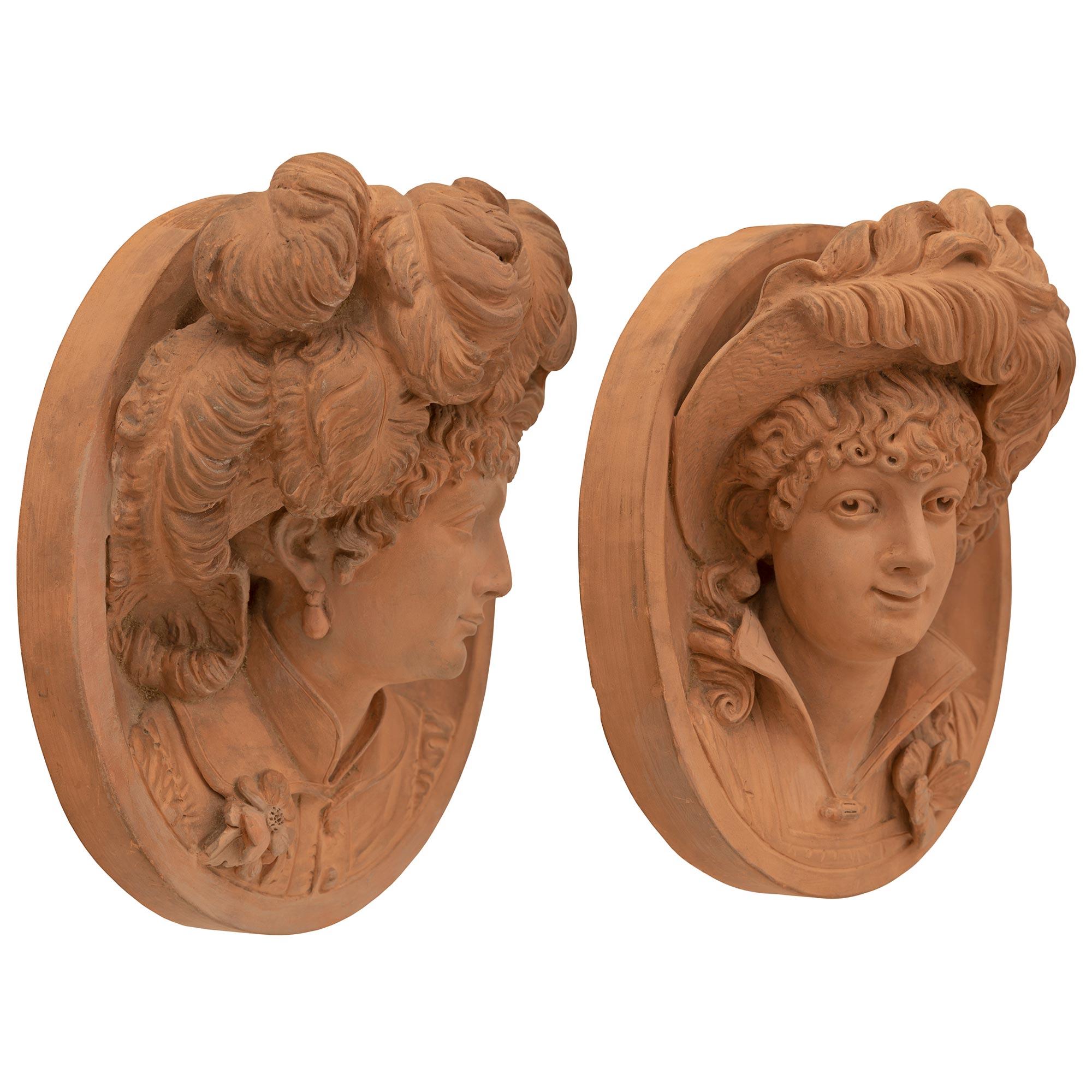 A beautiful and wonderfully executed true pair of French 19th century Louis XVI st. Belle Époque period Terra Cotta decorative wall plaques signed N. Laval 1880. Each oval plaque displays exceptional attention to detail with the left plaque