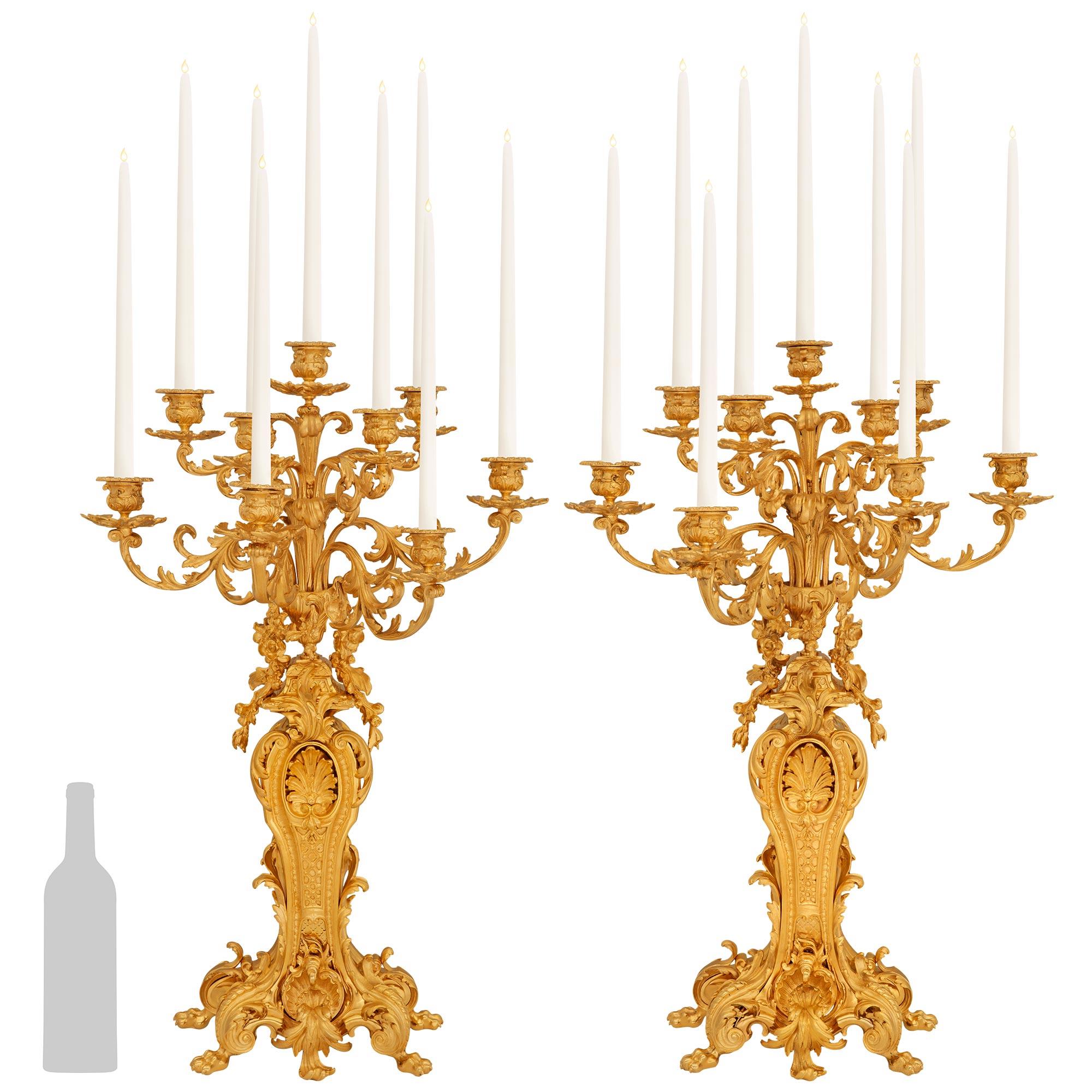 Una coppia spettacolare e ricca di dettagli di candelabri francesi del XIX secolo in stile Luigi XV in Ormolu. Ogni splendido candelabro a nove bracci è sollevato su piedi ad artiglio sotto a volute foliate in Ormolu riccamente cesellate. Le volute