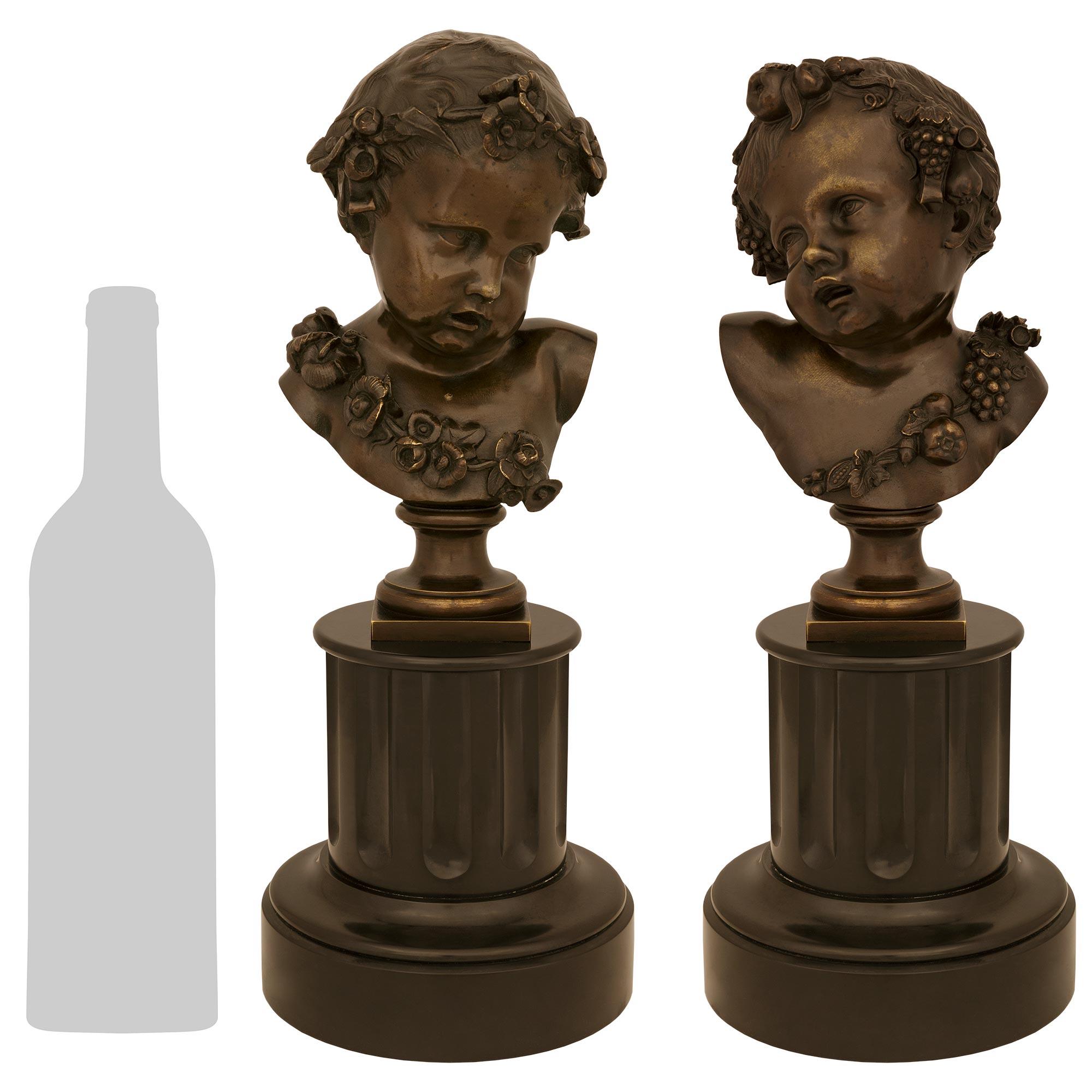 Un'affascinante coppia di statue in bronzo patinato e marmo nero del Belgio risalenti al XIX secolo Luigi XVI. Ogni elegantissima statua è sollevata da una base circolare in marmo nero del Belgio con un disegno screziato sotto la colonna scanalata.