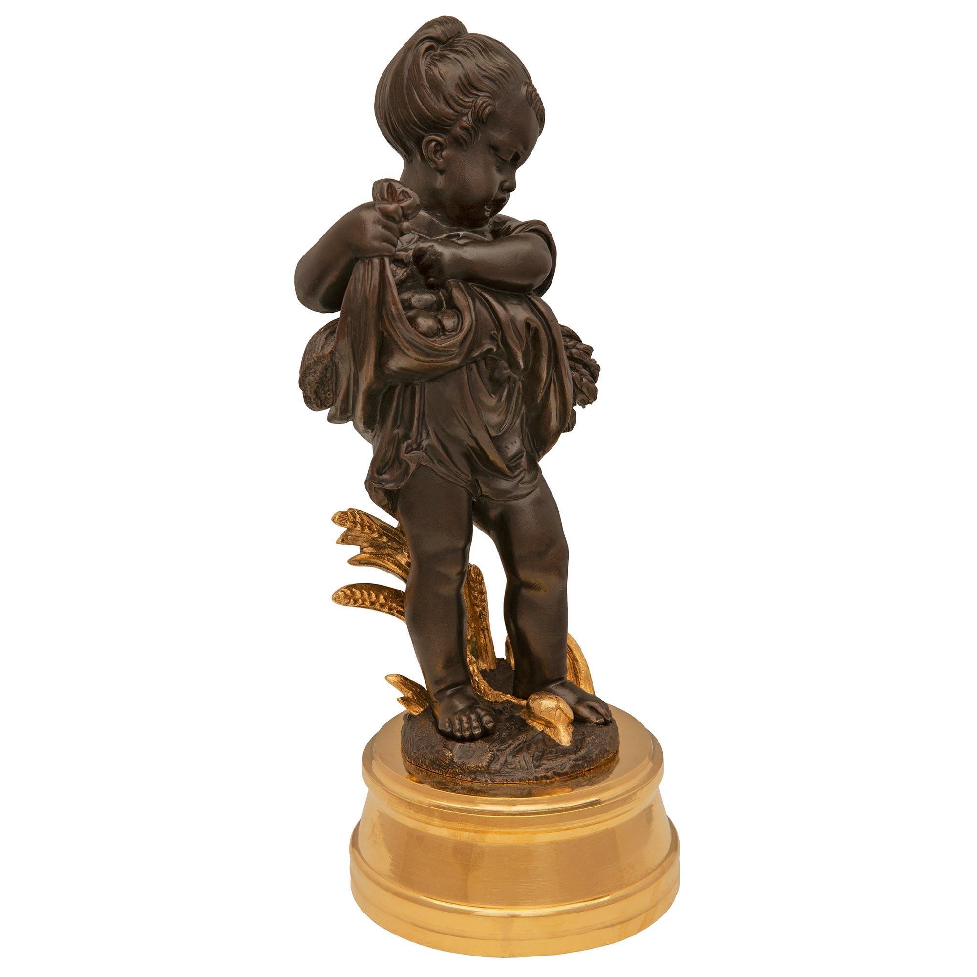 A beautiful and very high quality true pair of French 19th century Louis XVI St. Ormolu and patinated bronze statues signed A. Mahuet. Each small scale statue depicting summer and autumn is raised by an elegant circular mottled ormolu base with a