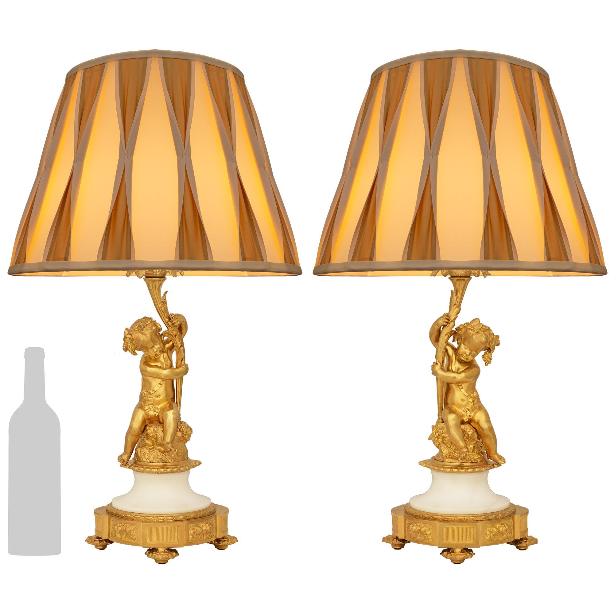Una meravigliosa coppia di stravaganti lampade francesi del XIX secolo in stile Luigi XVI con ormeggio e marmo. Ogni lampada è sollevata su un piedino foliato sotto la base circolare con blocchi rettangolari sporgenti e pannelli foliati. Sopra lo