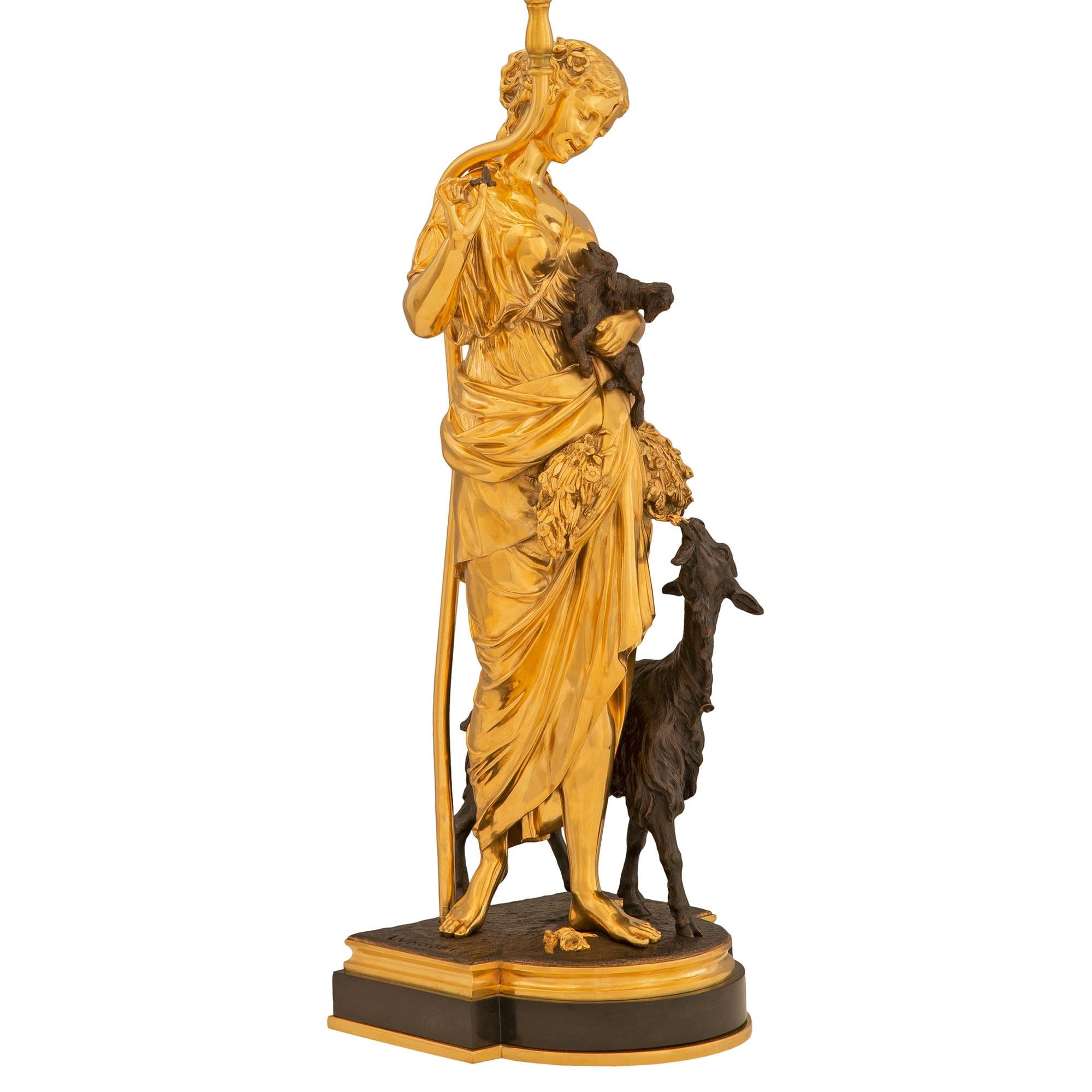 Paire de lampes en bronze doré et patiné de style Louis XVI du 19ème siècle, de très haute qualité. Chaque lampe est surélevée par une élégante base en bronze patiné avec de fins filets en bronze doré moucheté et une façade arrondie. La lampe de