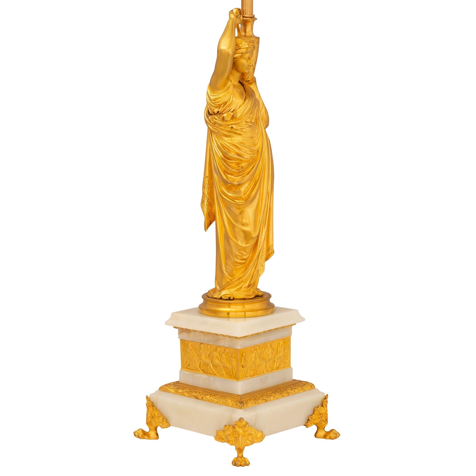 A stunning true pair of French 19th century Neo-Classical st. ormolu and onyx lamps. Each elegant lamp is raised by a square onyx base with four handsome paw feet fitted ormolu mounts. The stepped onyx base displays a richly chased wrap around