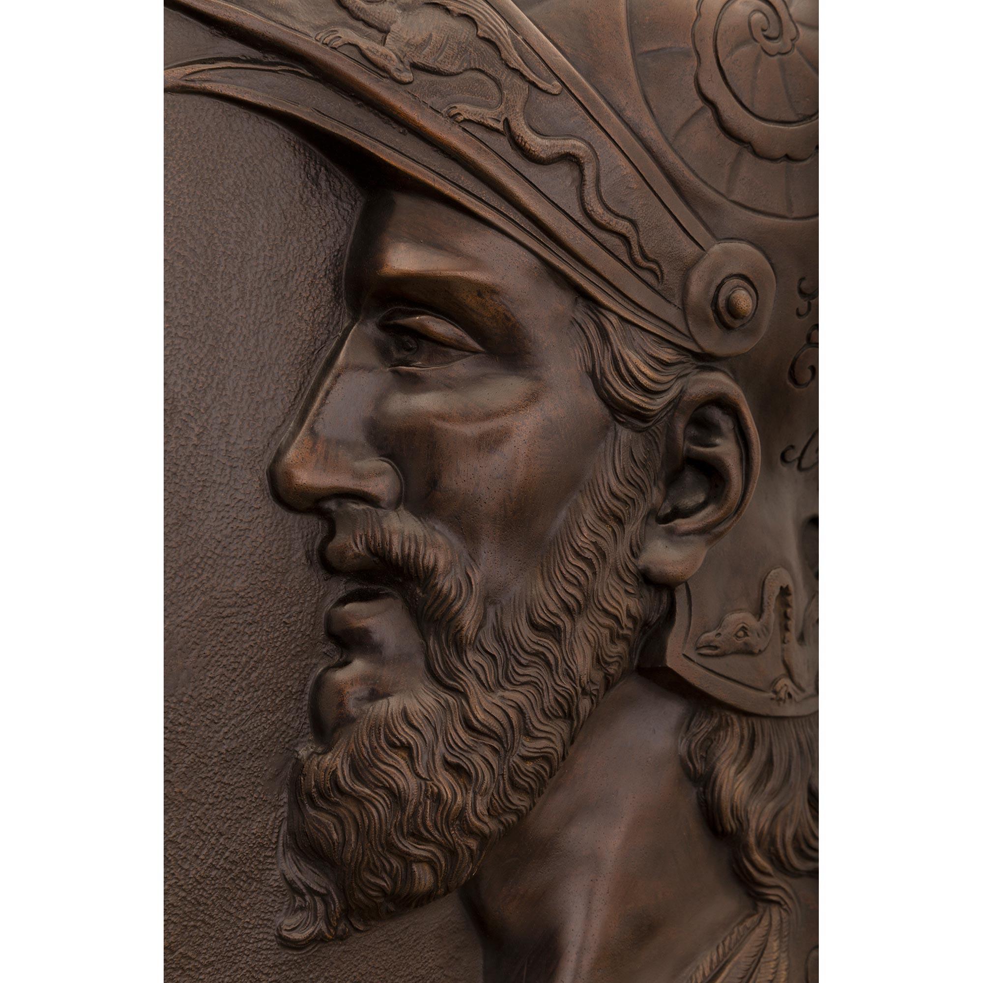 Una notevole coppia di targhe decorative da parete in bronzo patinato del XIX secolo. Ciascuna targa rettangolare, meravigliosamente realizzata, raffigura soldati che indossano un'impressionante armatura riccamente cesellata con draghi, superbe ali,
