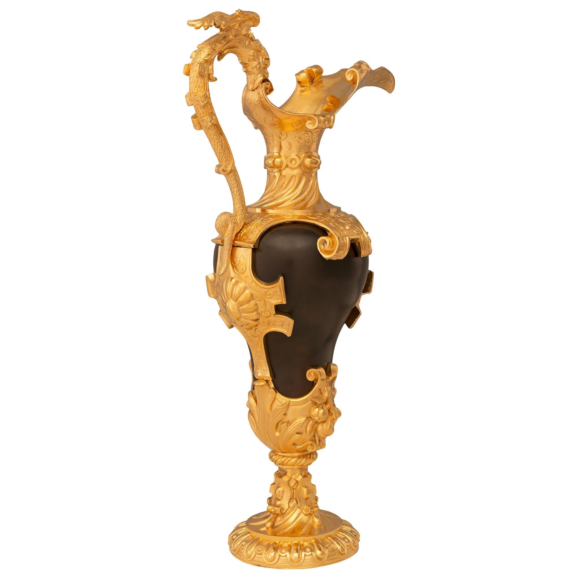 A striking true pair of French 19th century Renaissance st. ormolu and patinated bronze ewers. Each ewer is raised by a superb circular reeded base with a fine spiral fluted socle shaped pedestal support with family crest like reserves. The