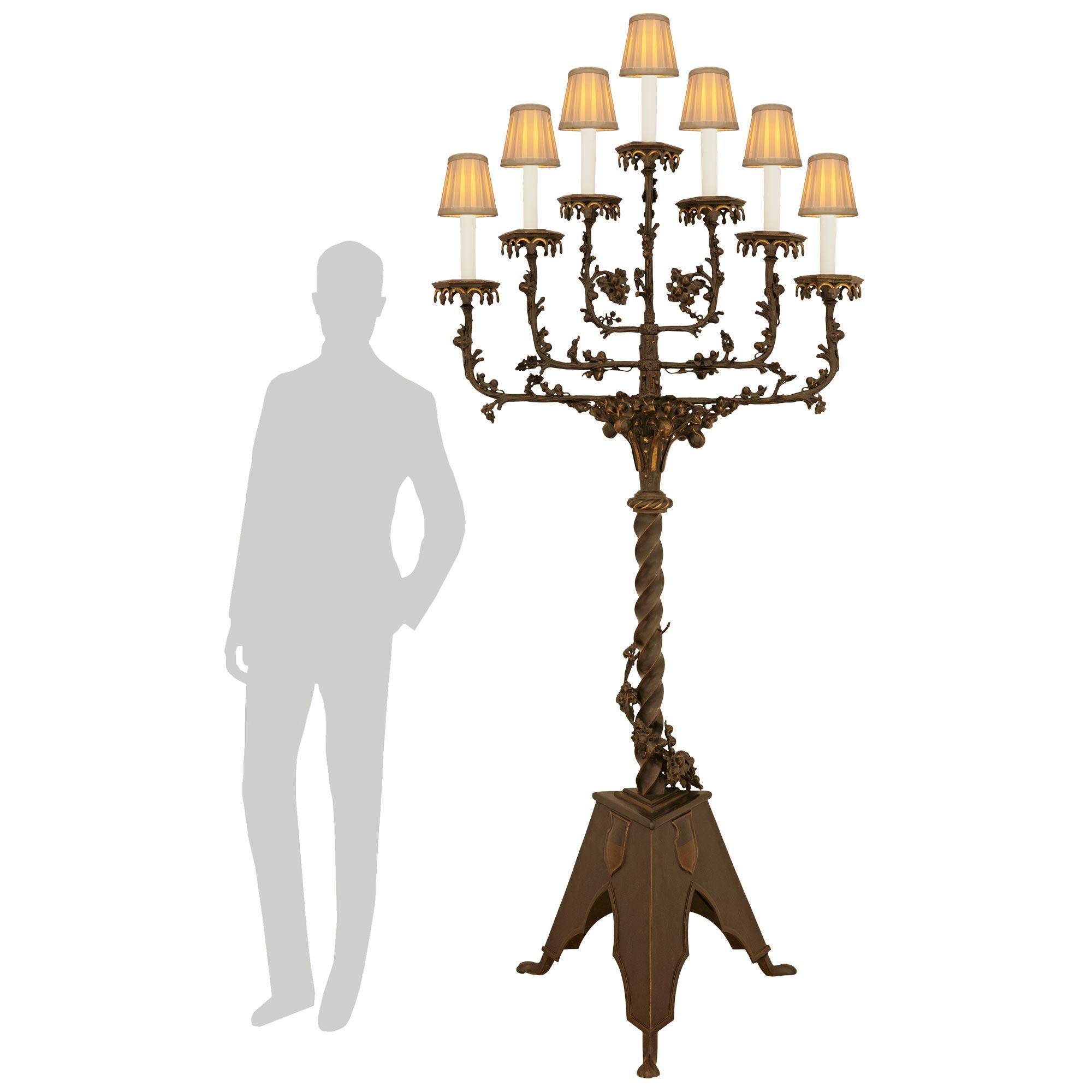 Una coppia di lampade da terra in bronzo patinato e dorato del XIX secolo, impressionante e di grande effetto. Ciascuna Torchière in scala palatina è sollevata su una base a forma triangolare con gambe inferiori sporgenti che fiancheggiano i lati