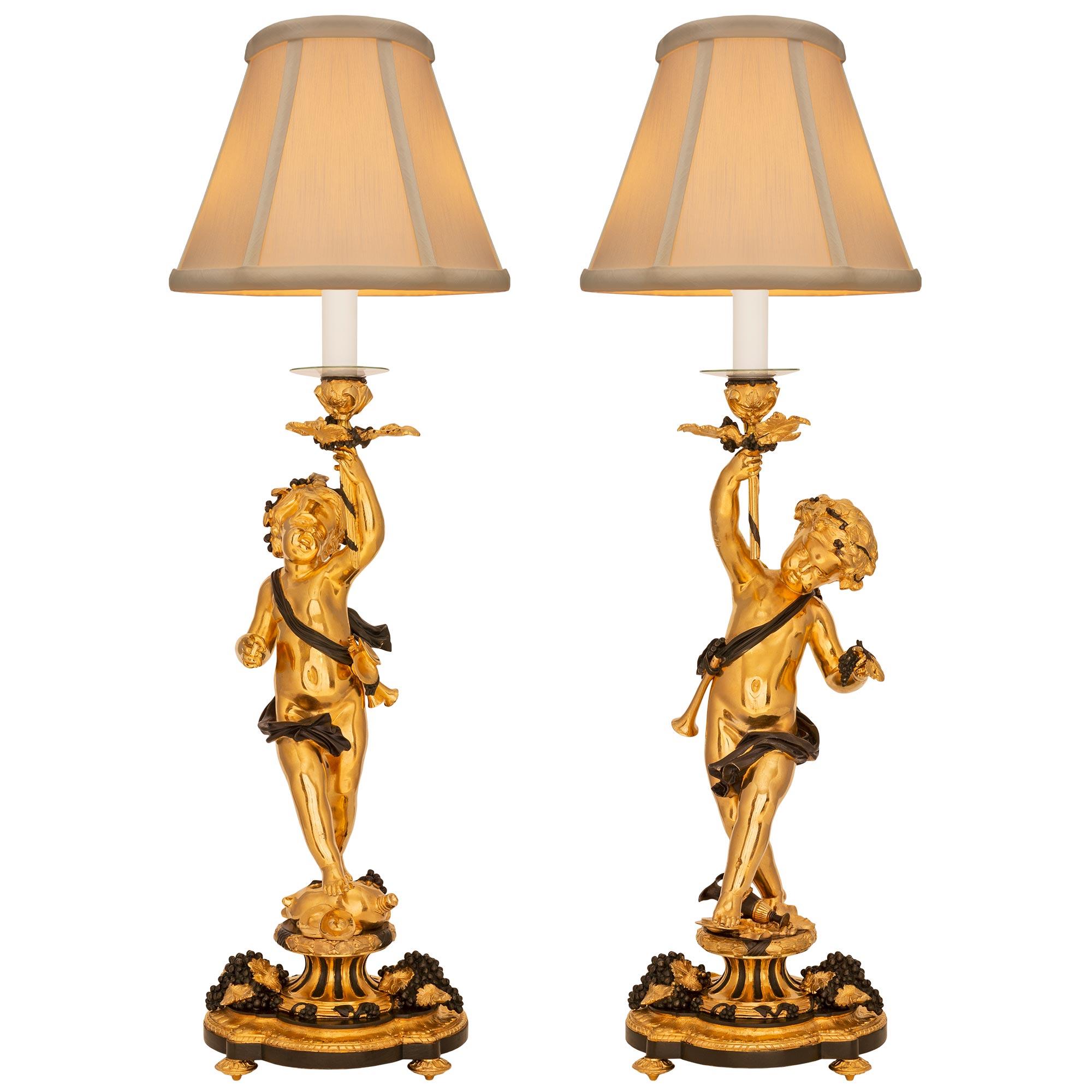 A remarkable and most decorative true pair of French 19th century Louis XVI st. Belle Époque period ormolu and patinated bronze lamps. Each lamp is raised by an elegant scalloped shaped base with fine foliate topie shaped feet, lovely grape clusters