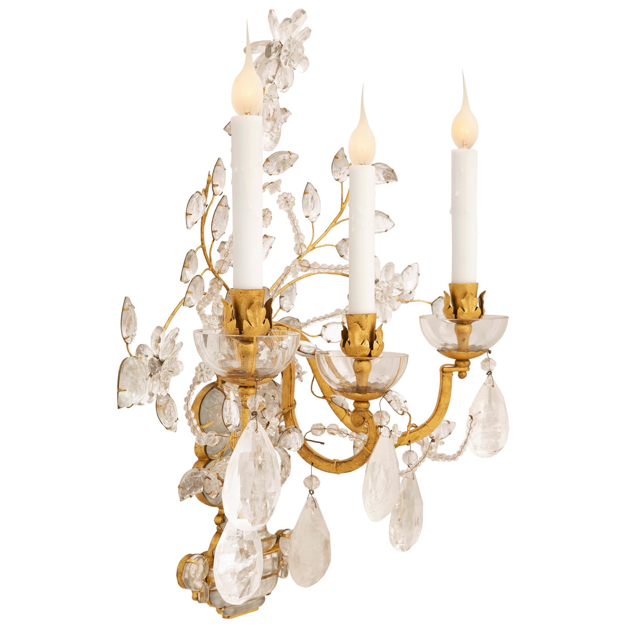 A stunning large scale true pair of French turn of the century Louis XVI st. Crystal, Rock crystal and Gilt metal sconces, attributed to Maison Bagues. Each three arm sconce is centered by an spectacular extremely decorative rock crystal urn with