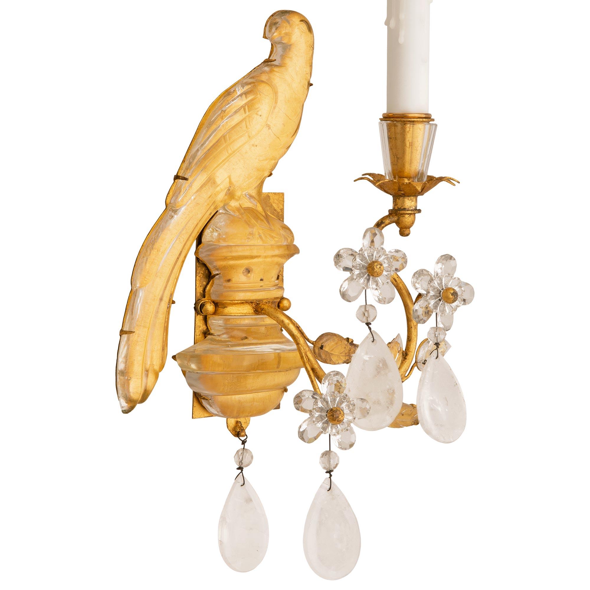 A beautiful and most decorative true pair of French turn of the century Louis XVI st. Rock Crystal and Gilt Metal sconces, attributed to Maison Baguès. Each single arm sconce displays a perched Rock Crystal parrot held by a Gilt Metal back plate.
