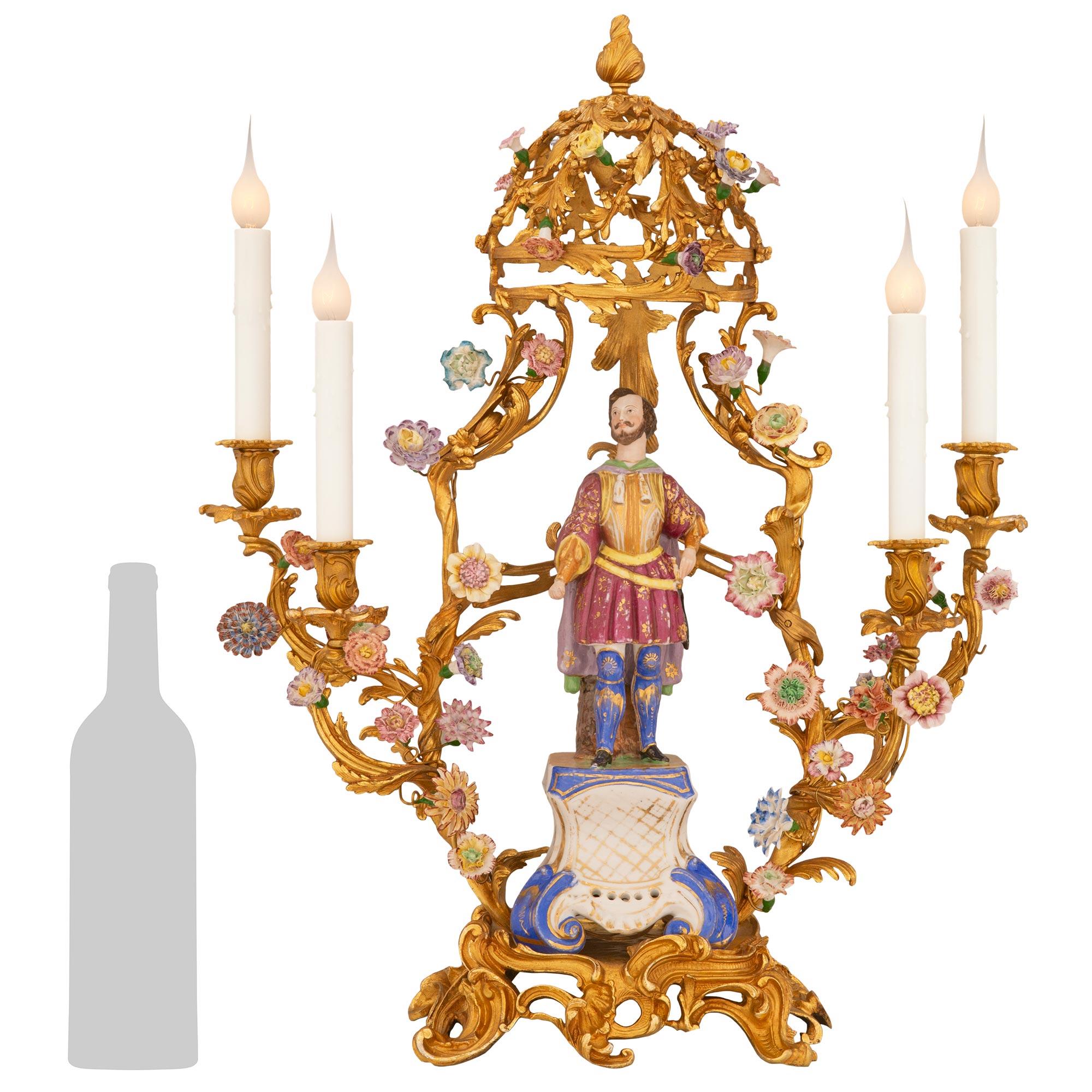 A striking and extremely decorative true pair of French turn of the century Louis XV st. ormolu and Saxe porcelain candelabra lamps. Each four arm lamp is raised by a beautiful pierced ormolu base with wonderful scrolled foliate designs and lovely