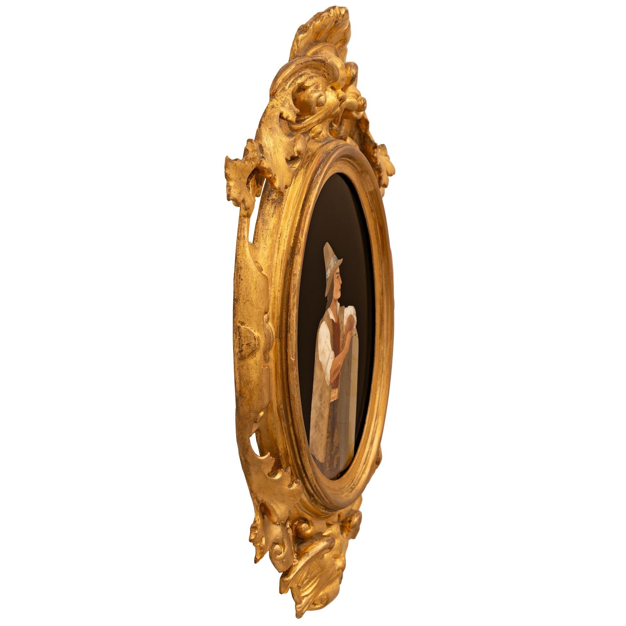Ein wunderschönes und äußerst dekoratives Paar italienischer Marmortafeln aus Giltwood und Pietra Dura aus dem 19. Jahrhundert im Stil Louis XV. Dieses wunderbare Plakettenpaar ist in einen gesprenkelten, ovalen Rahmen mit einem äußeren