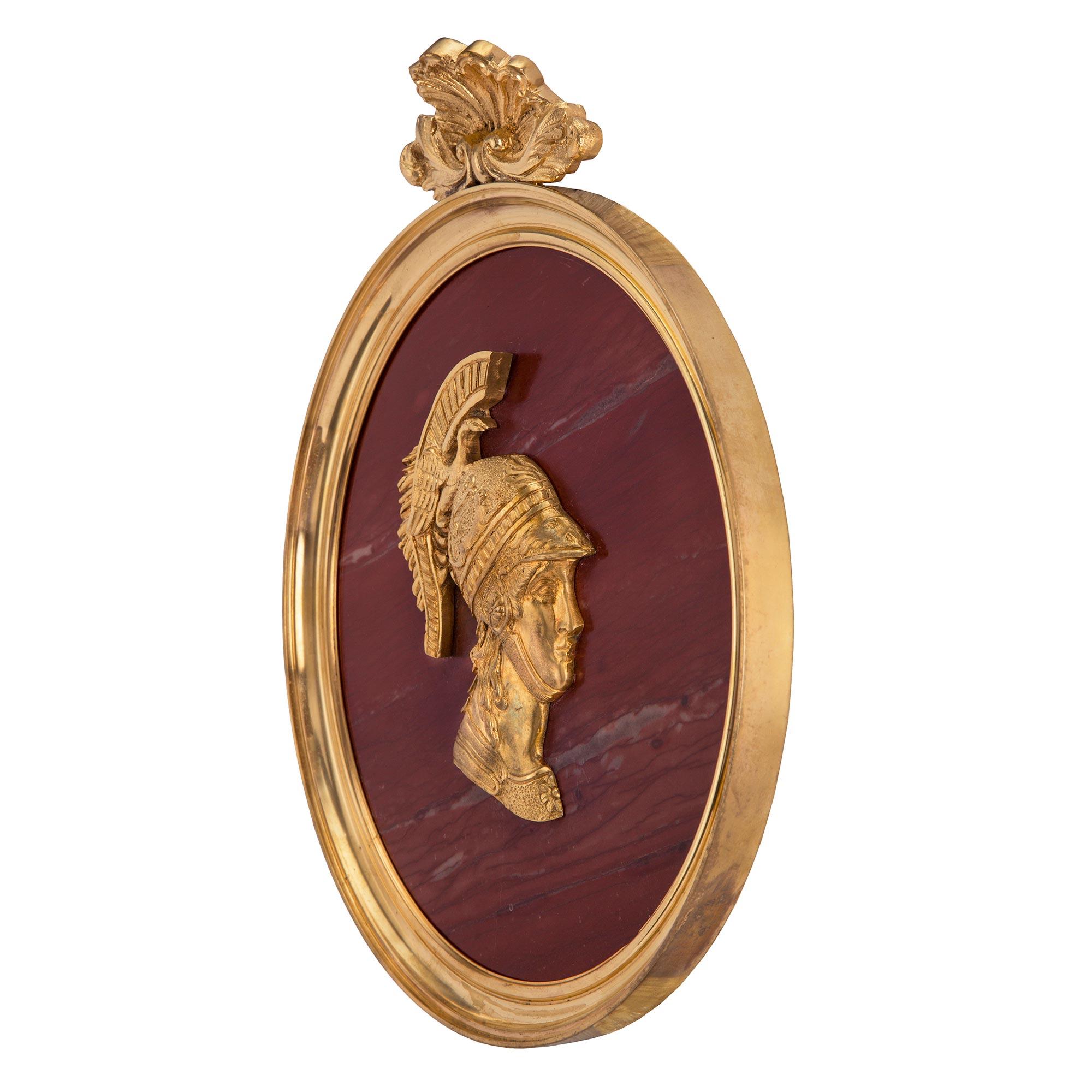 A most elegant and high quality true pair of Italian 19th century Neo-Classical st. Rosso Antico marble and ormolu wall plaques. Each striking plaque is framed within a circular mottled ormolu border with a fine seashell reserve at the top flanked