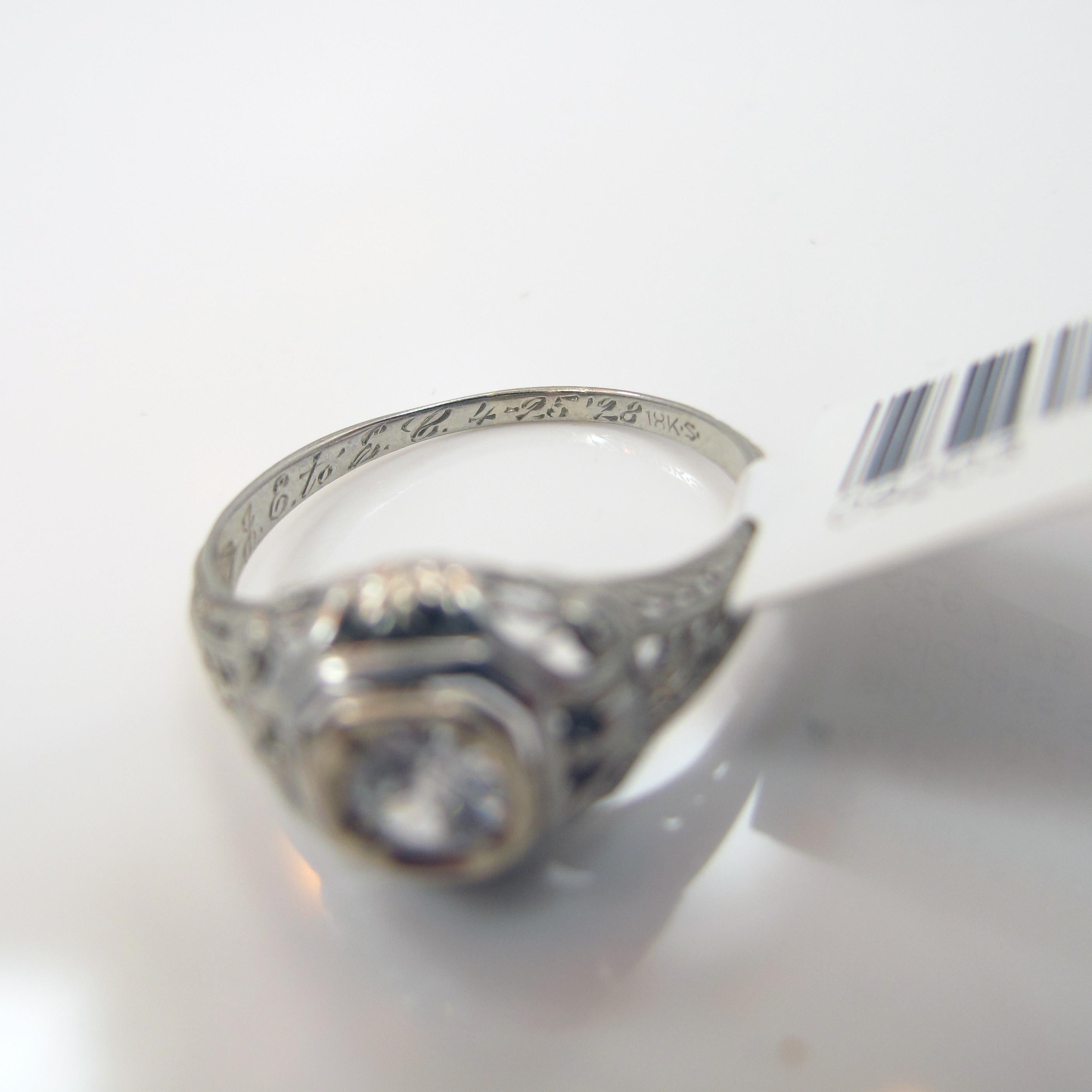 True vintage diamond ring set in 18k white gold. The ring contains one 4.15mm round old cut diamond weighing approximately 0.25ct, near colorless, SI  in clarity. The ring has engraving detail throughout. Size 7.75. Inquire about
