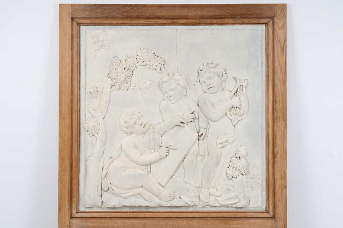 Trumeau. Flachrelief aus geschnitztem Kalkstein aus dem 18. Jahrhundert, das eine Allegorie der Künste darstellt: eine Putte hält eine Leier und zwei andere eine Farbpalette in einem Garten. Eichenholzrahmen, der traditionell im zwanzigsten