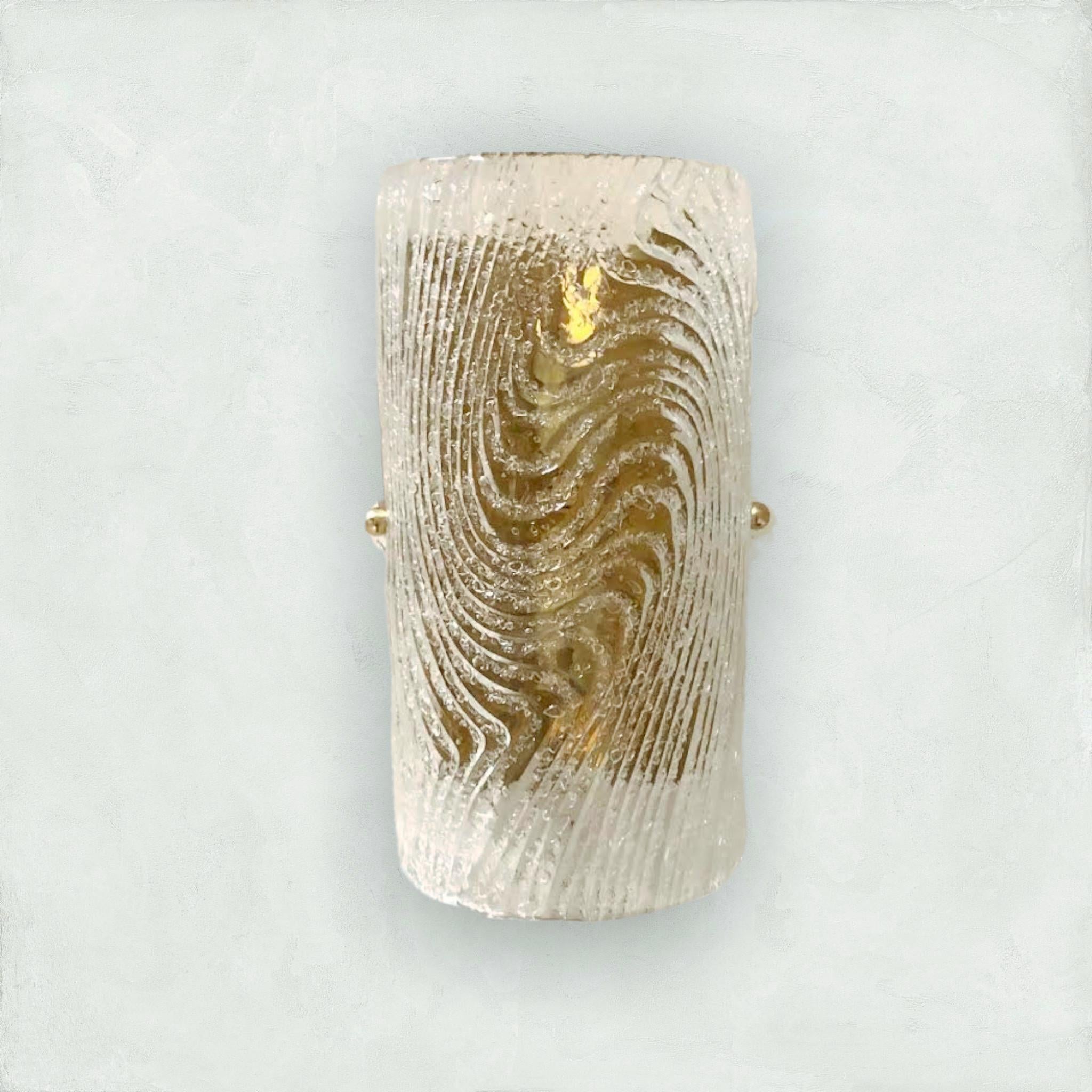 Italian wall light with clear Murano glass hand blown into cylinder shaped diffuser with textured patterns and granular effect using Graniglia technique, mounted on full brass back-plate / designed by Fabio Bergomi for Fabio Ltd / Made in Italy
2