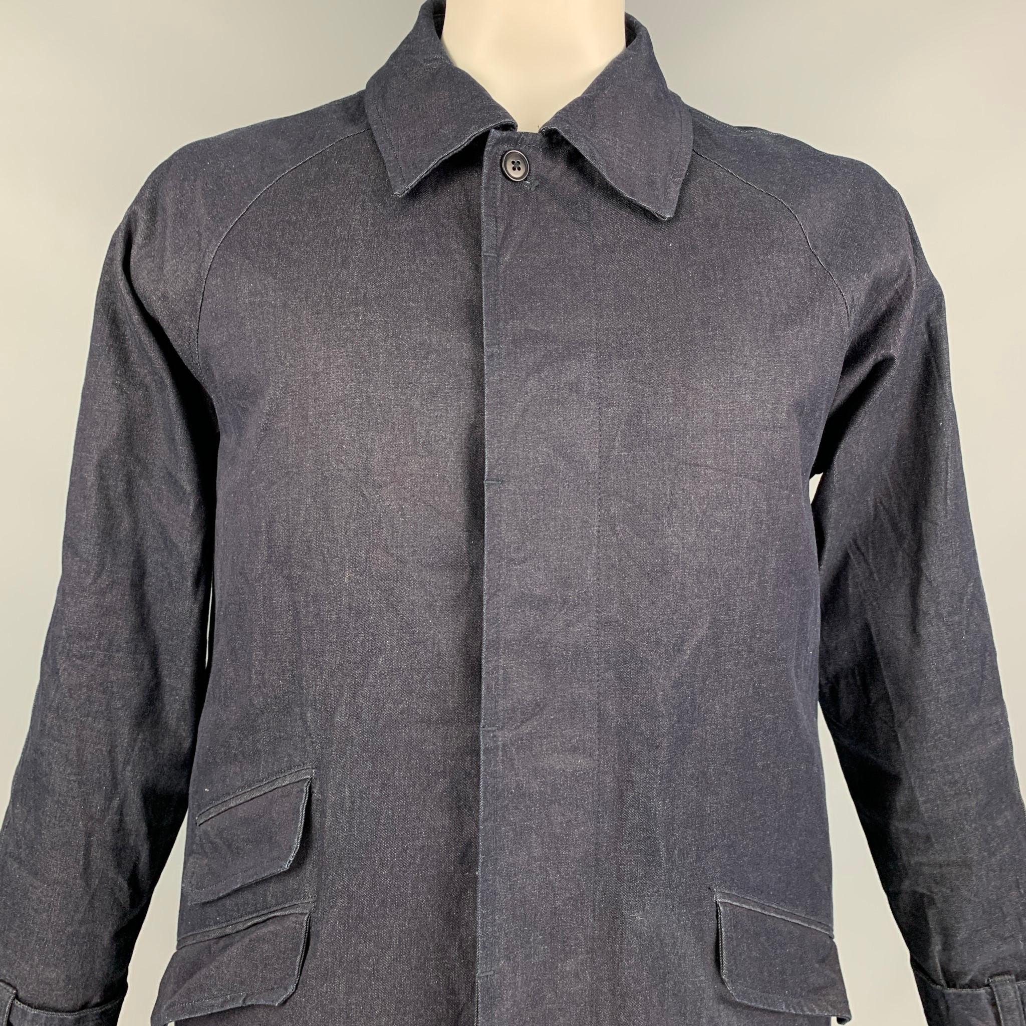 TS (S) coat comes in a indigo cotton / polyurethane with a down fill liner featuring a pointed collar, buttoned sleeves, flap pockets, and a hidden placket closure. Made in Japan. 

Excellent Pre-Owned Condition.
Marked: 4

Measurements:

Shoulder: