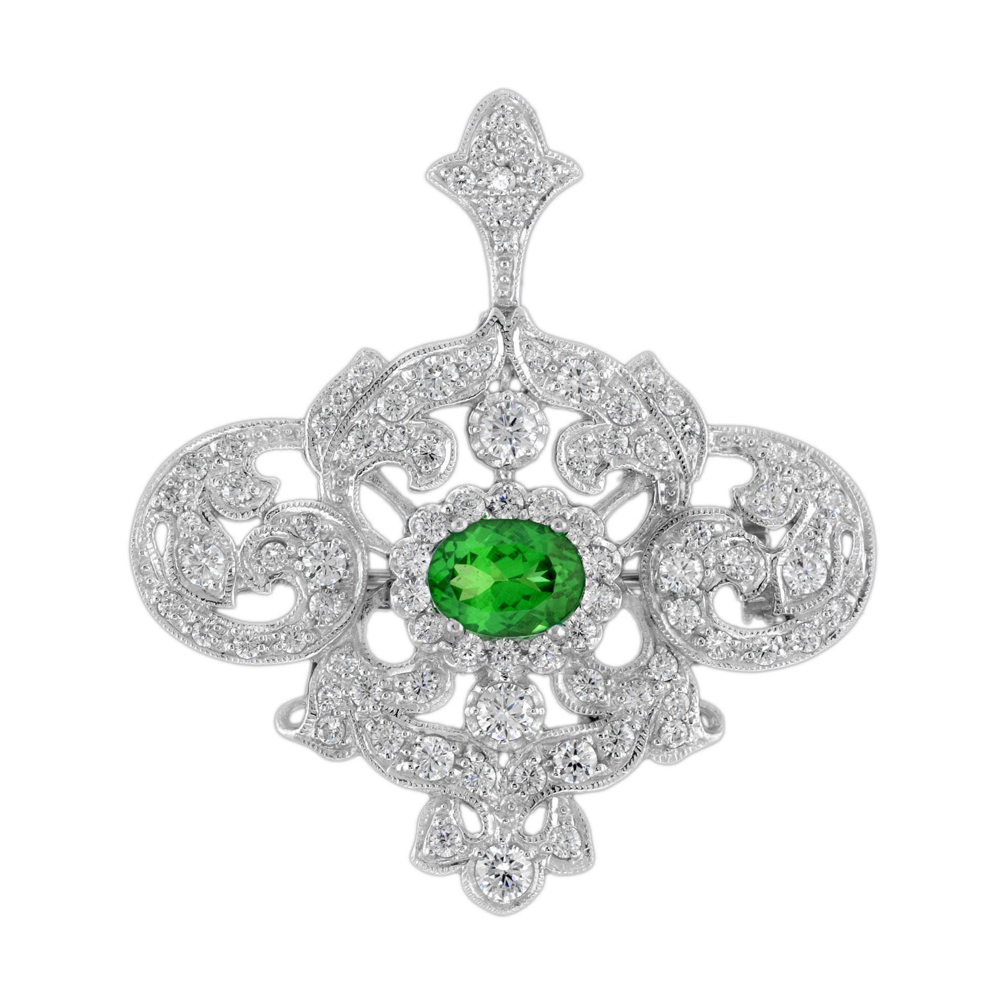 This is an impressive vintage inspired brooch pendant set in 18k white gold featuring a gorgeous oval cut green tsavorite gemstone measuring 8 x 6 mm. The brooch is further set with stunning round cut diamonds of H color and SI clarity. Super