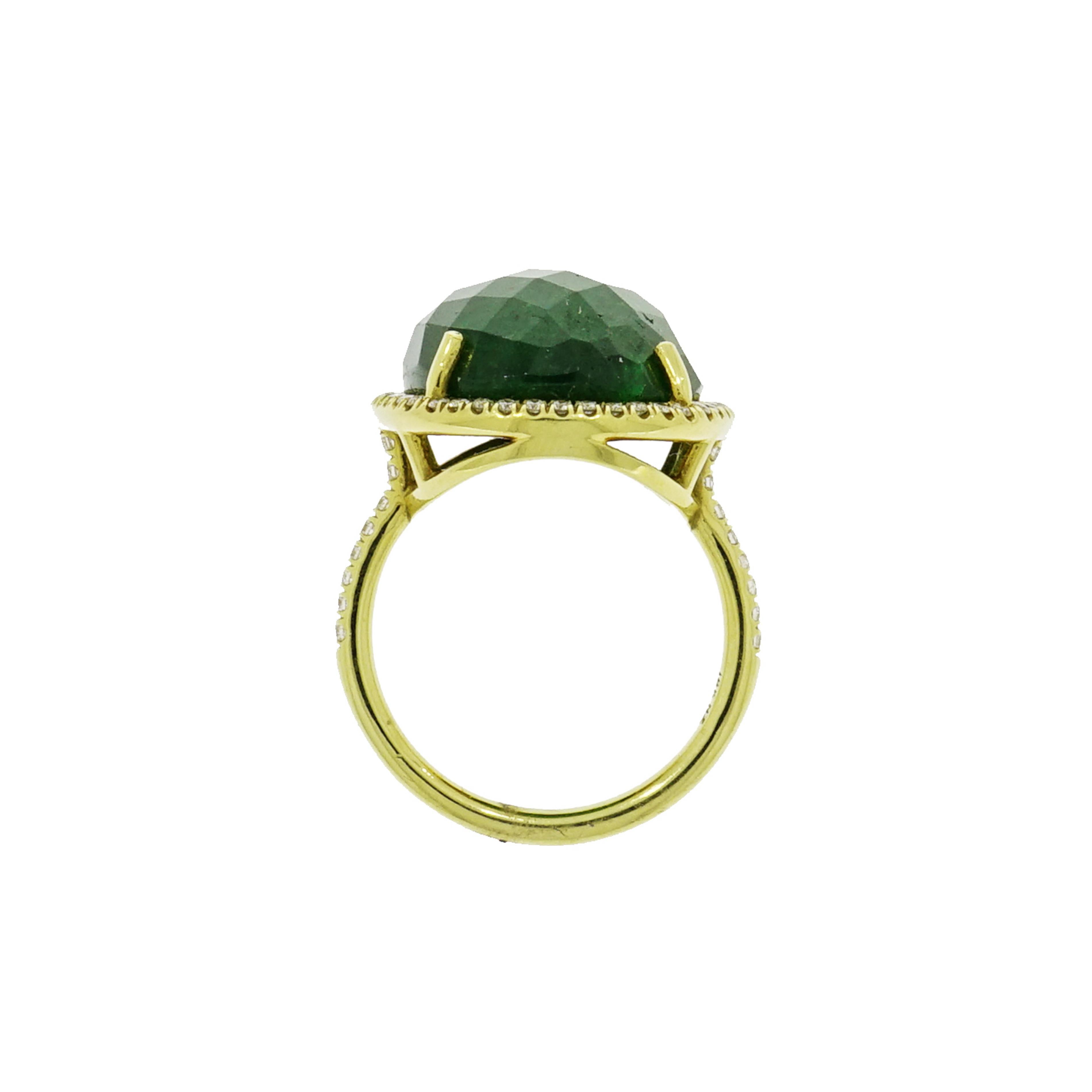 Bring some visual interest to your cocktail ring... Abstract designs are a chic look on the ring finger and will definitely garner attention.
This gorgeous deep green faceted Tsavorite is set in yellow gold and framed by a brilliant halo of 0.38