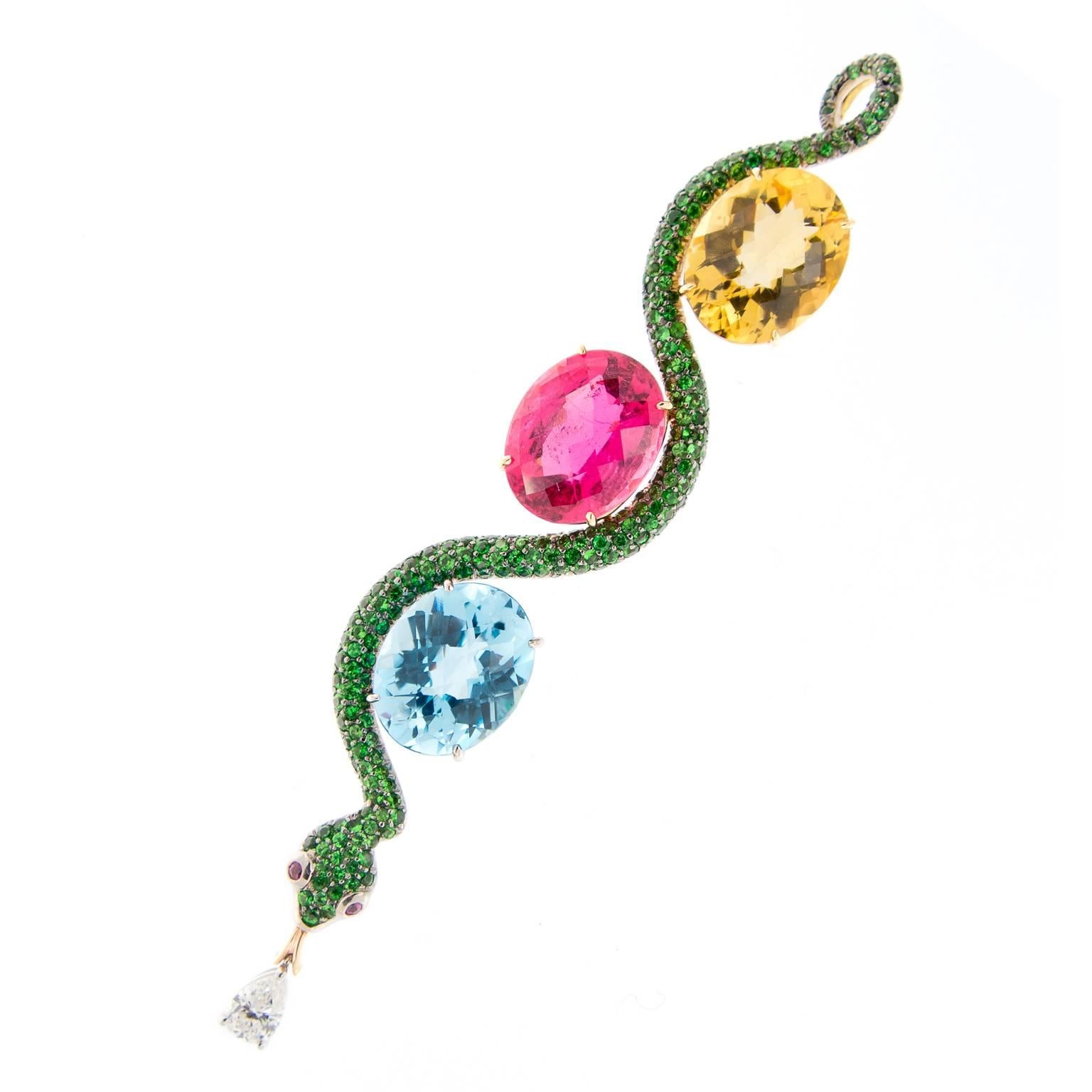 Stunning one-of-a-kind pendant displays a beautiful combination of color! Contemporary serpent design is crafted in 18k yellow gold and contains citrine, rubelite, blue topaz, tsavorites and a pear shaped diamond drop. Pendent drops from a 16.5 inch