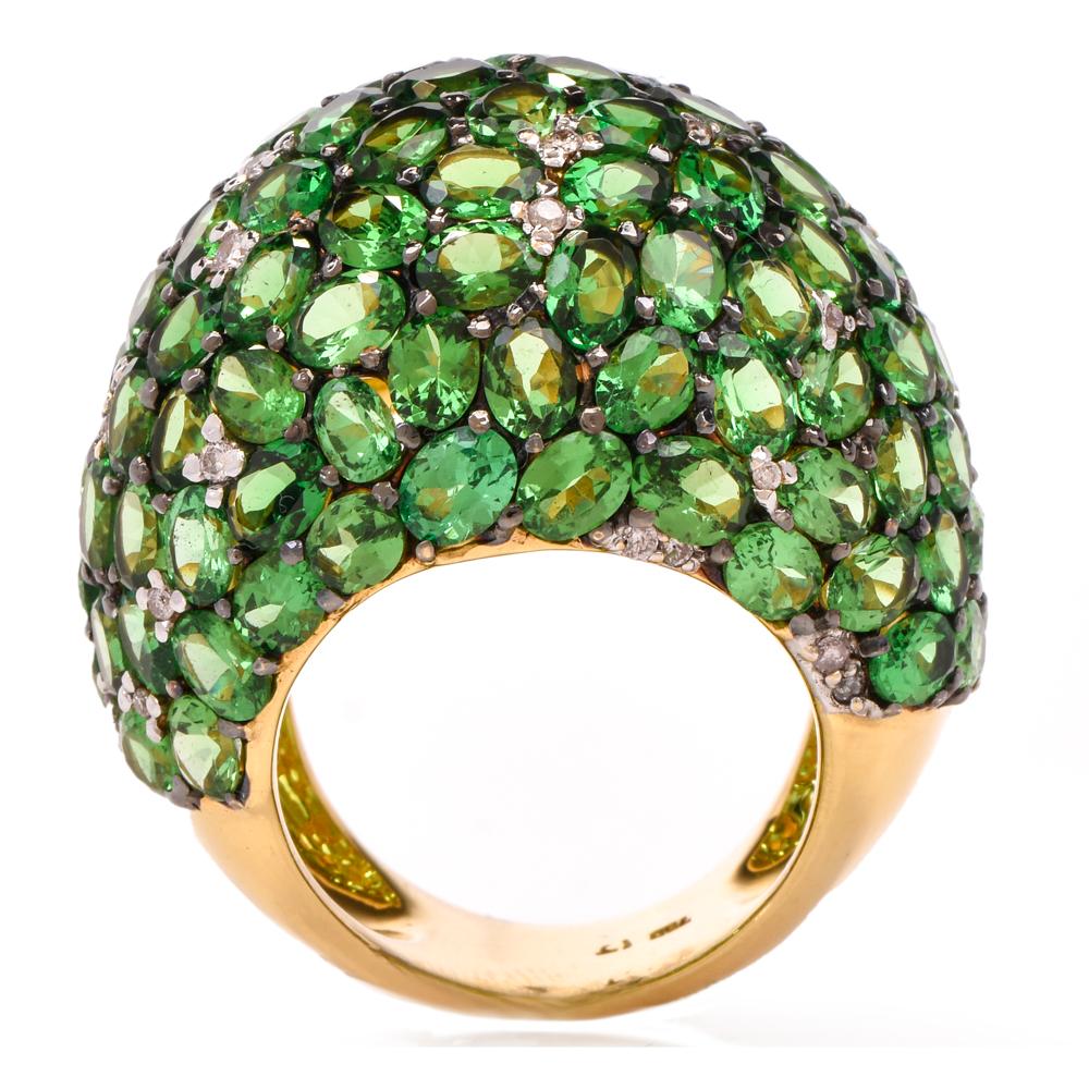 This stunning tsavorite and diamond cluster dome ring is crafted in 18K yellow gold. Pave set with oval shaped tsavorites approx. 25.35 carats and round cut diamonds approx. 0.50 carats, graded H-I color, and SI clarity. This opulent cocktail ring