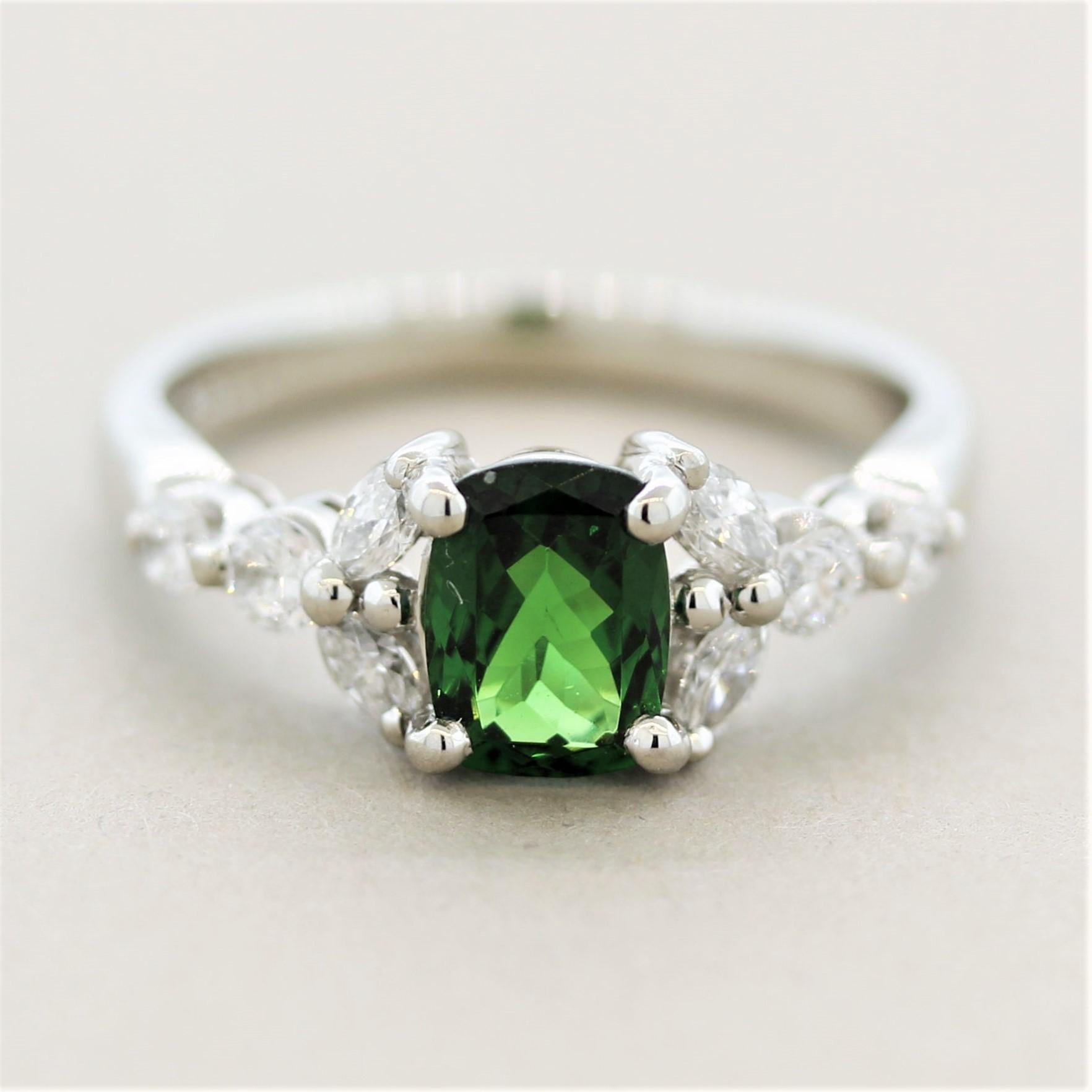 A gorgeous cushion-shaped tsavorite takes center stage! It weighs 0.97 carats and has a vivid rich green color seen in fine tsavorites. It is accented by 0.43 carats of round brilliant-cut and marquise-shaped diamonds. Hand-fabricated in platinum,