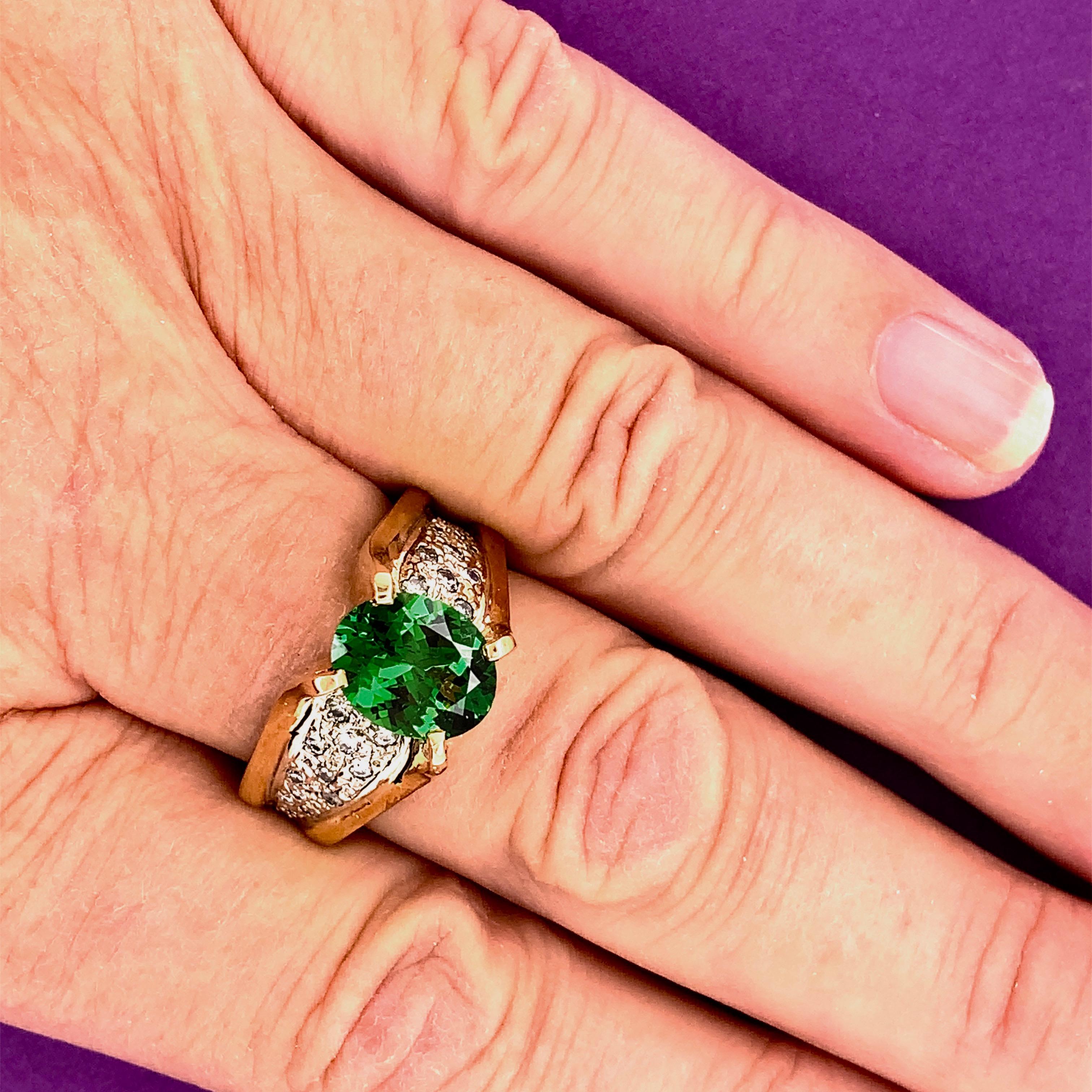  Green Garnets are a rather new discover. We set this nice VS grade Tsavorite Garnet from Tanzania in a 14-karat two tone gold ring, accented with 24 small round diamonds sprinkled in white gold pave style around the center stone.  They are SI