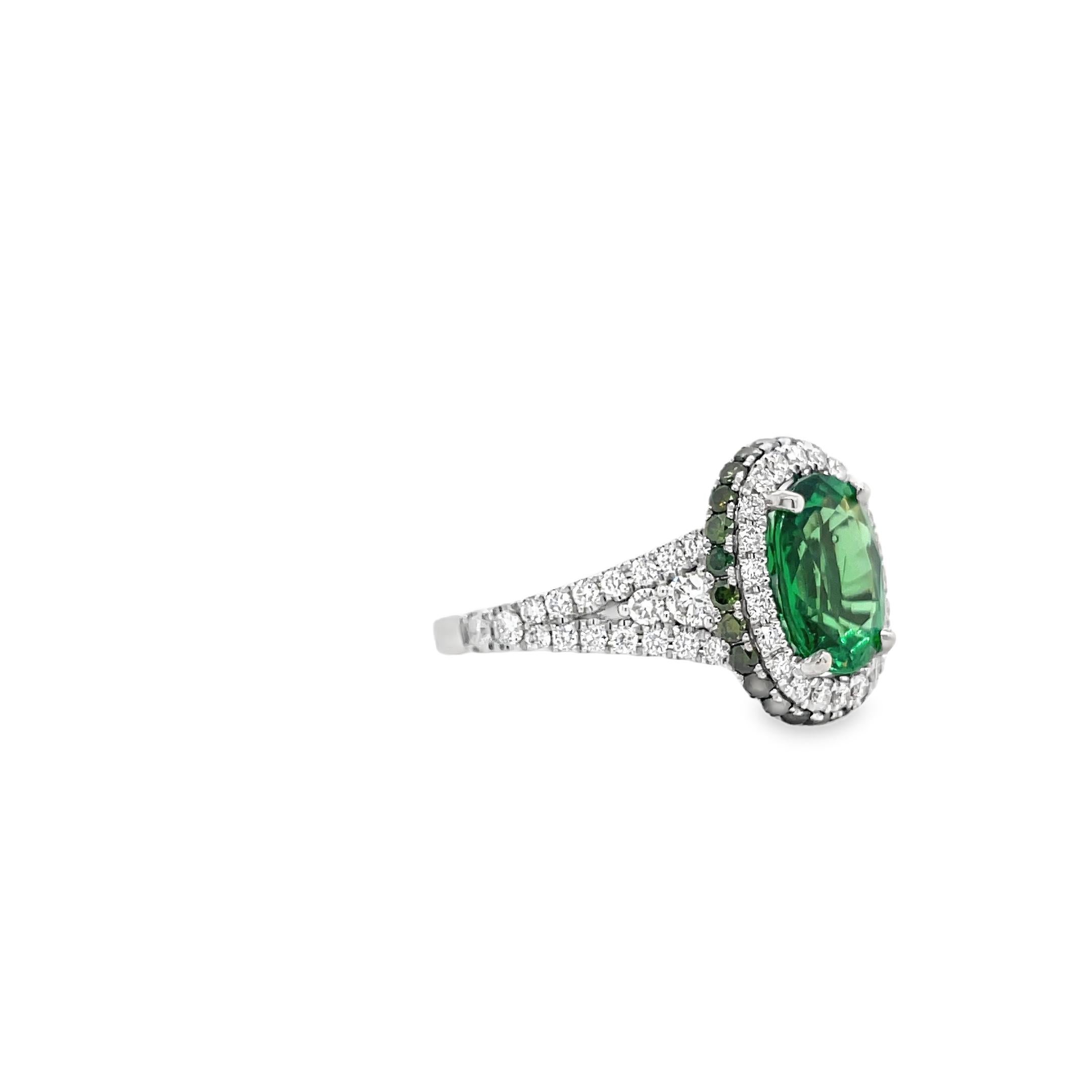 L'anello contiene un granato tsavorite centrale di forma ovale del peso di 3,05 carati. La pietra centrale è circondata da una doppia fila di diamanti tondi brillanti e piccoli granati tsavorite per un totale di 1,25 carati. La tsavorite e i